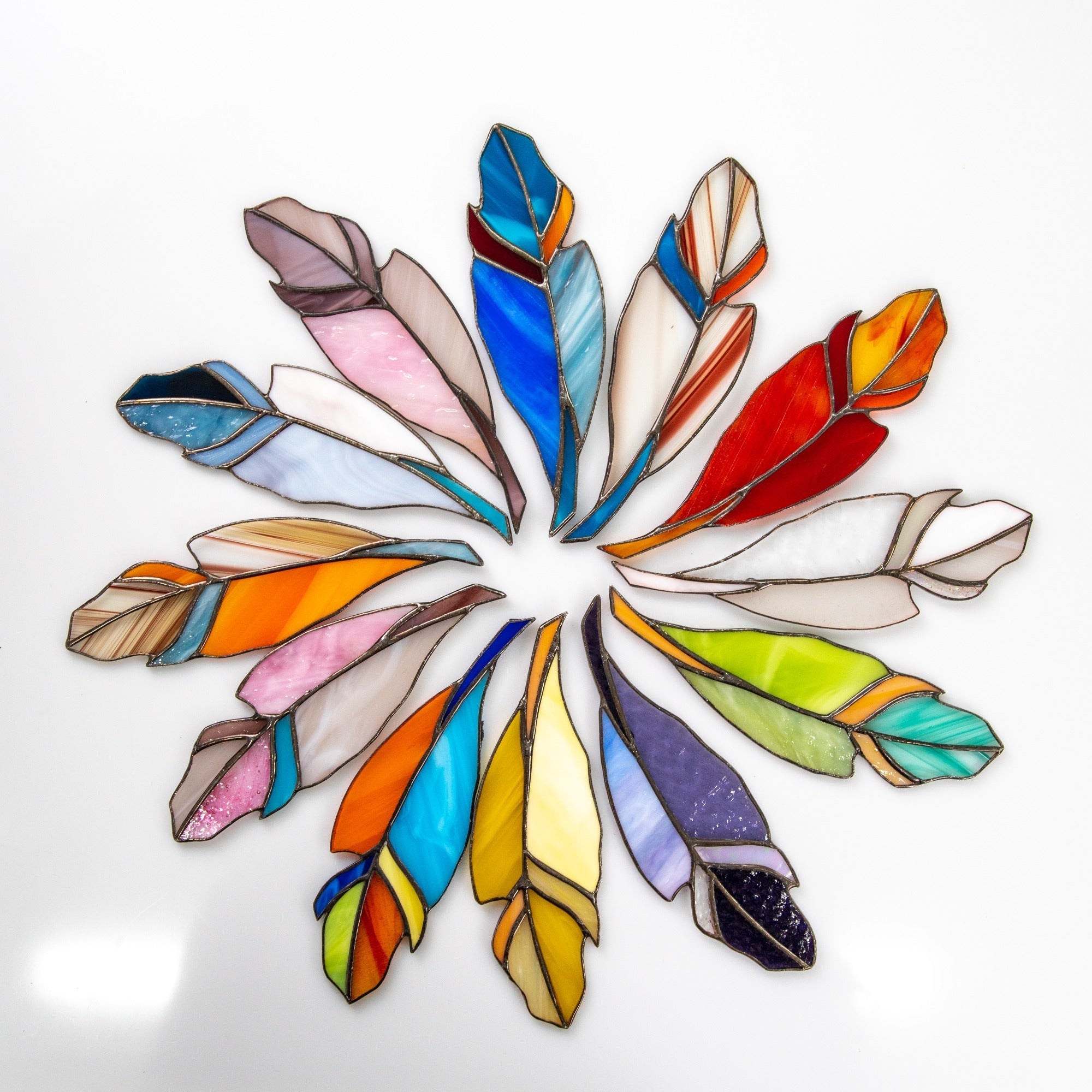 Colorful stained glass feather design on a white background