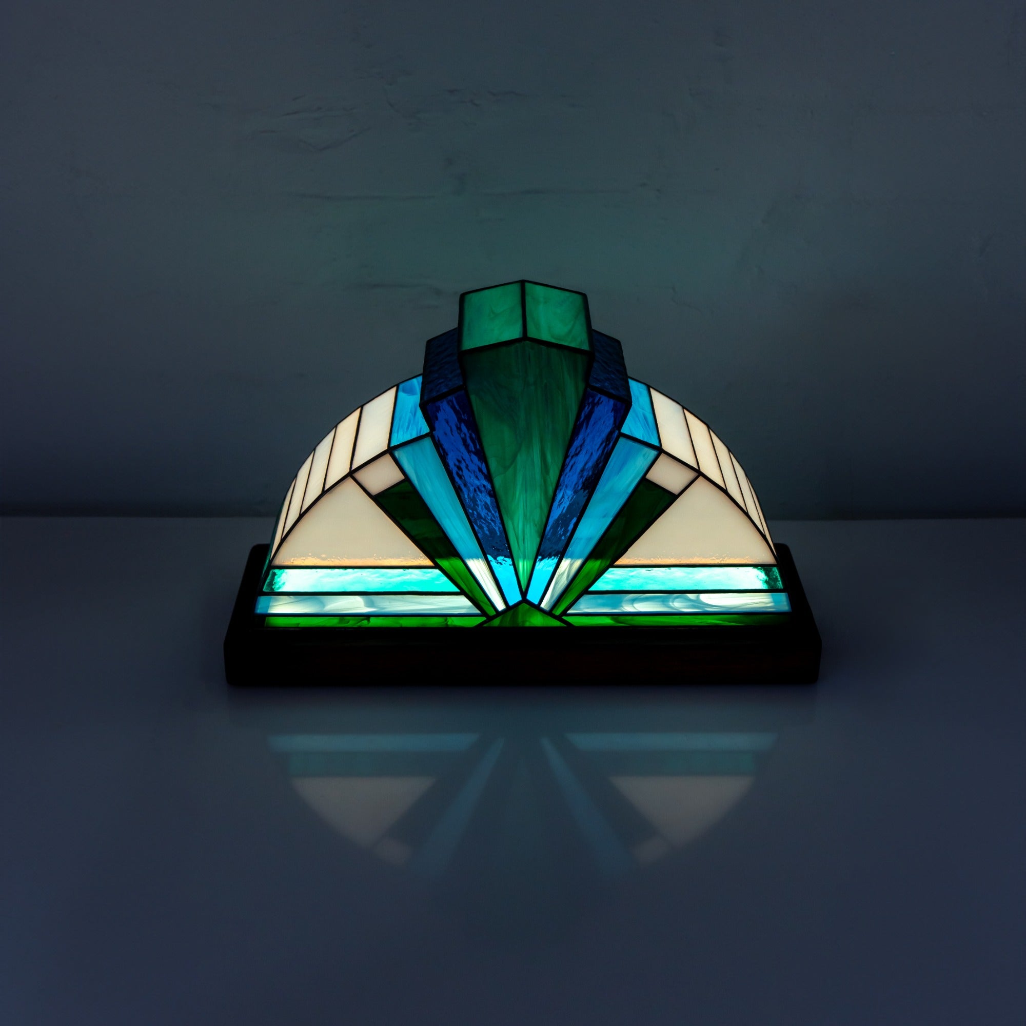 Stained glass lamp with geometric design on a dark background