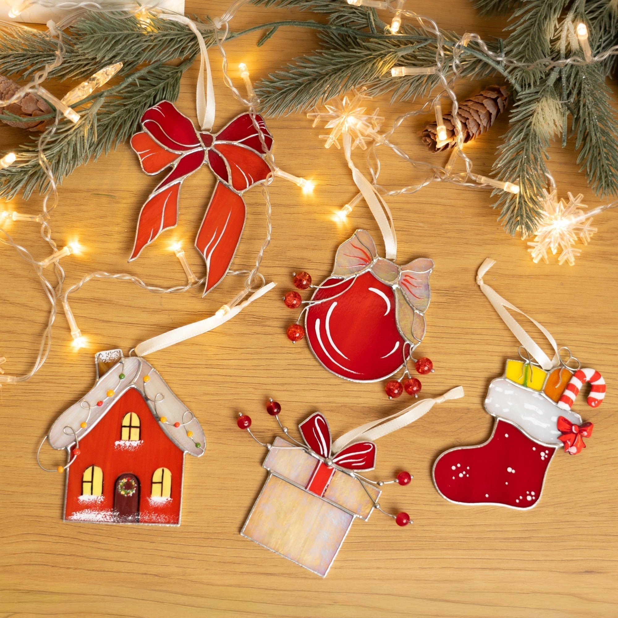 Decorative Christmas ornaments on a wooden surface with lights and berries.