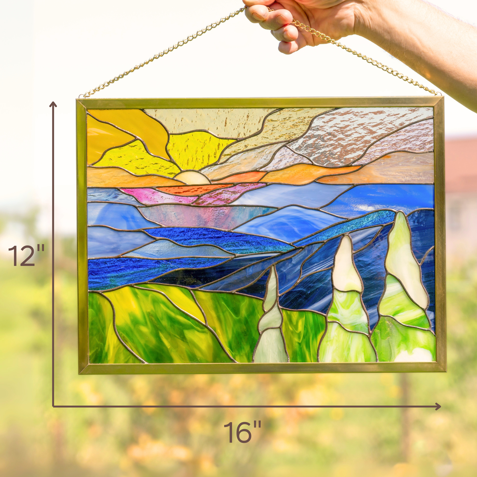 Hand holding Blue Ridge stained glass panel with dimensions 16 by 12 inches marked in the image