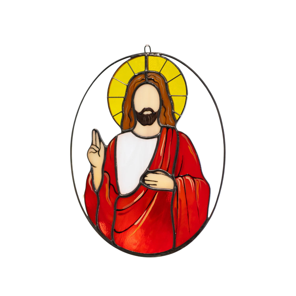 Jesus stained glass suncatcher on a white background - golden halo, brown hair, red robe over a white tunic and a hand raised in blessing, framed by an oval wire ring - handmade window decor