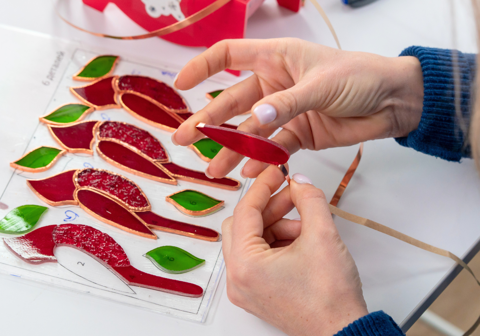 A person assembling stained glass pieces