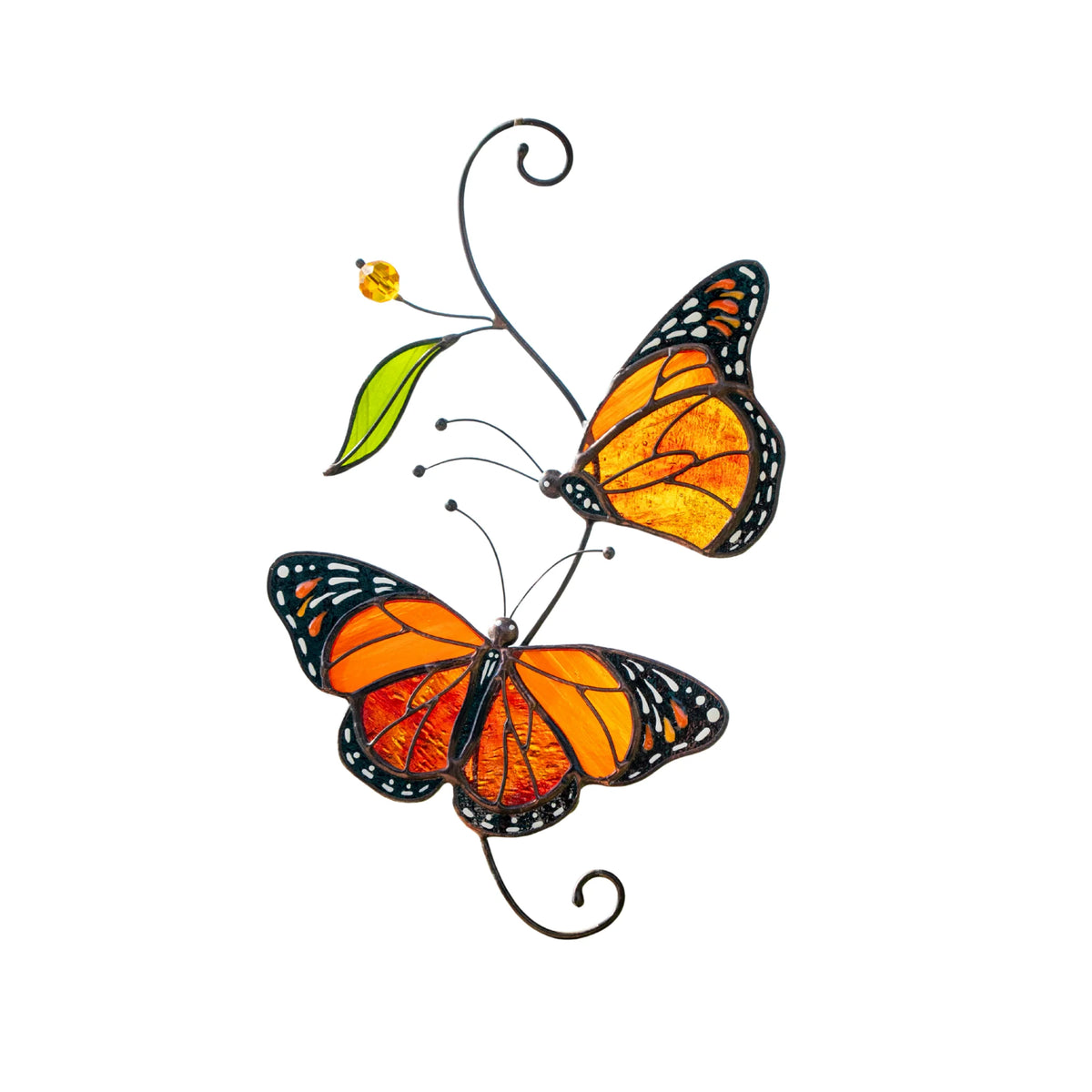 Pair of Monarch Butterflies stained glass suncatcher on a white background - two handmade orange glass butterflies on a curled wire stem with a green glass leaf and an amber bead