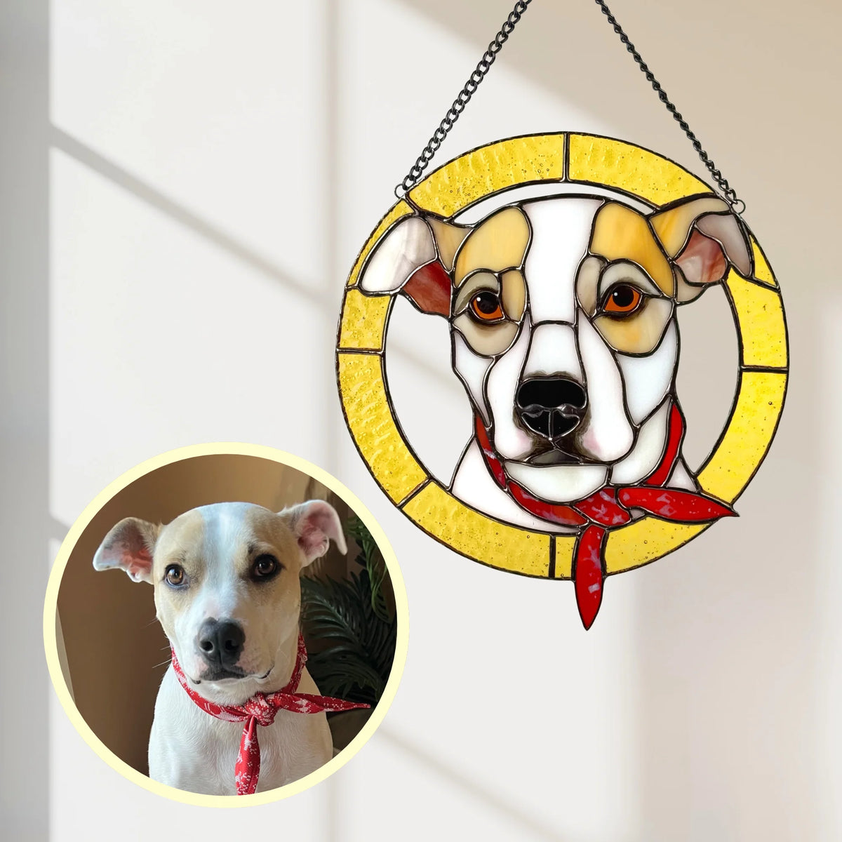Custom stained glass pet portrait of a white and tan dog in a red bandana inside a round yellow glass border, hanging by a window next to the original photo - a handmade custom dog suncatcher