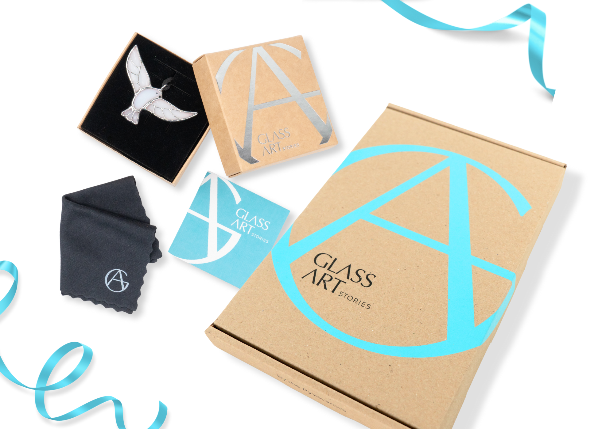 A glass bird pendant, cleaning cloth, business card, and box with GLASS ART STORIES branding