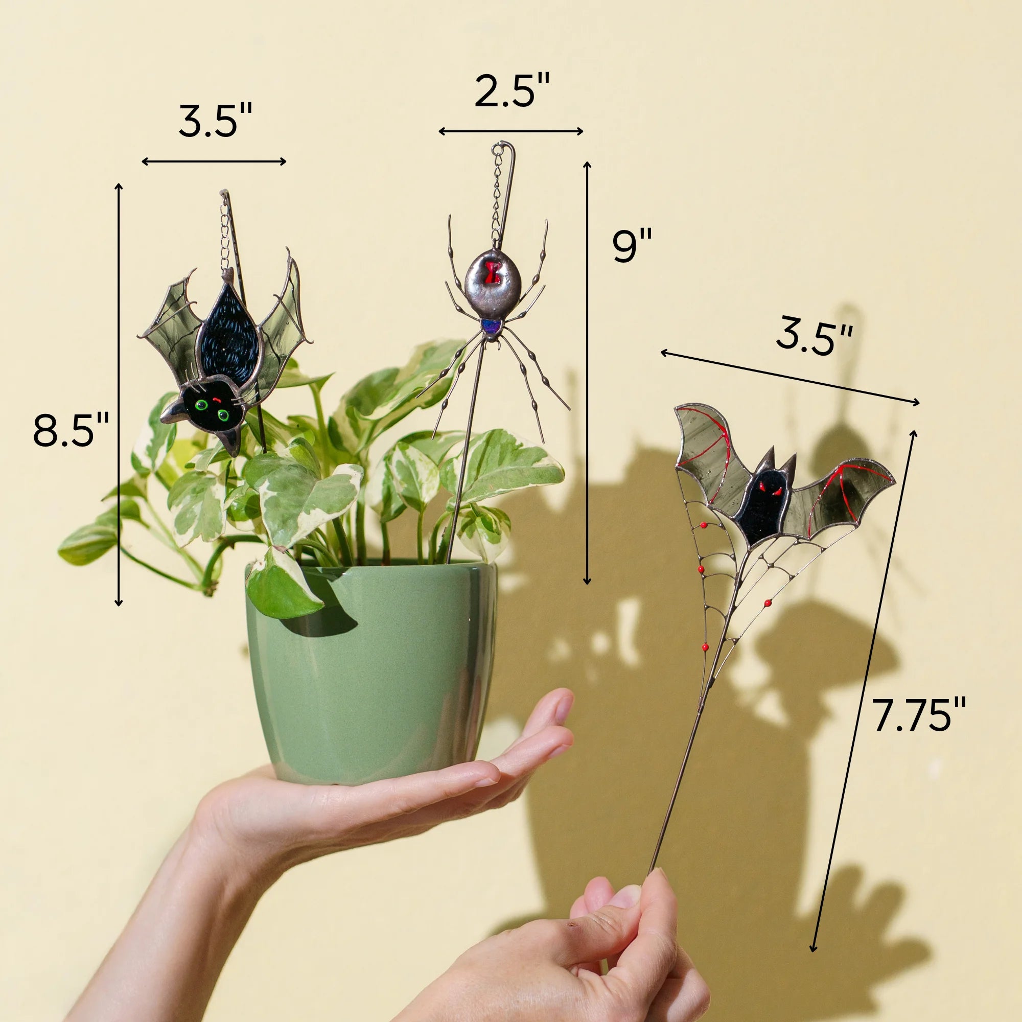 This stained glass plant stake dimensions infographic shows three spooky items: a hanging bat measuring 8.5 by 3.5 inches, a spider measuring 9 by 2.5 inches, and a bat on a web measuring 7.75 by 3.5 inches.