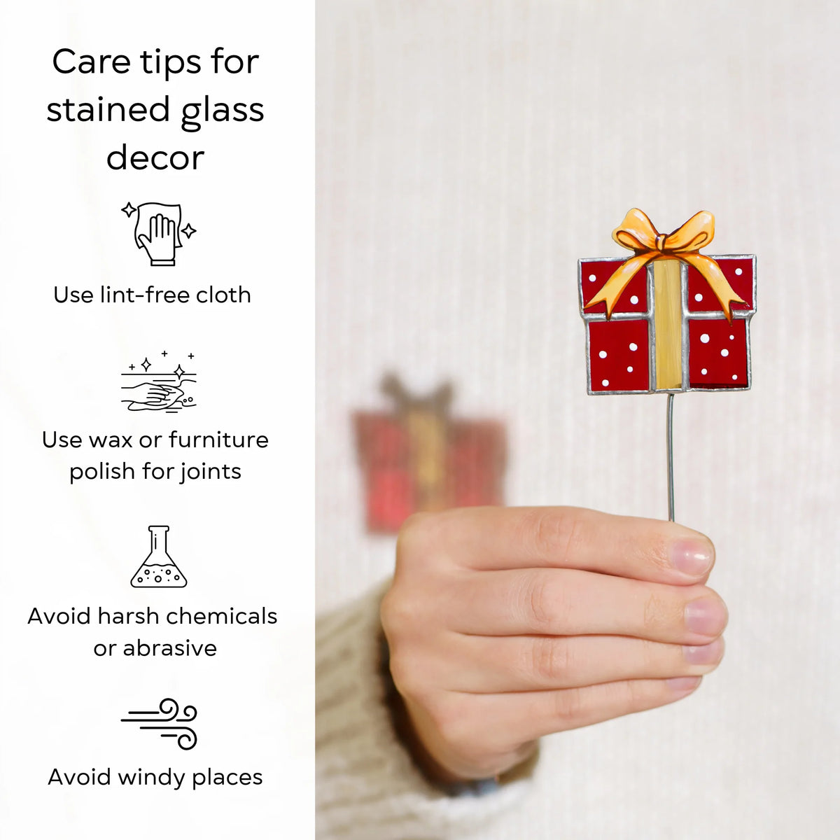 Hand holding the red gift box stained glass plant stake - care tips: use a lint-free cloth, use wax or furniture polish for the joints, avoid harsh chemicals and windy places