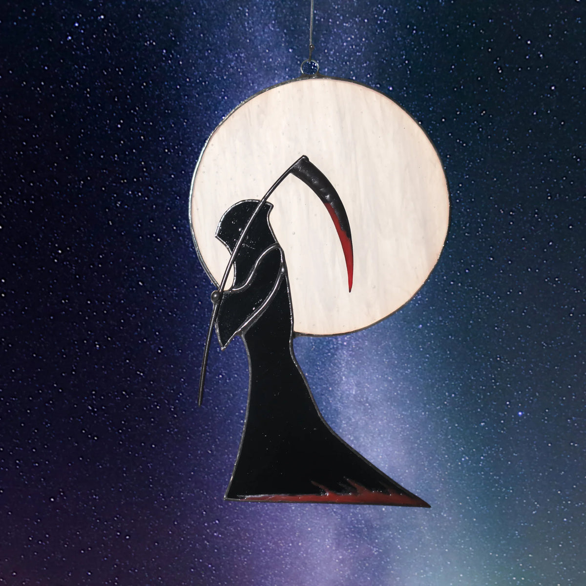 Grim Reaper Halloween stained glass window hanging against a starry night sky, the opal moon glowing behind the black hooded figure - handmade gothic window decor