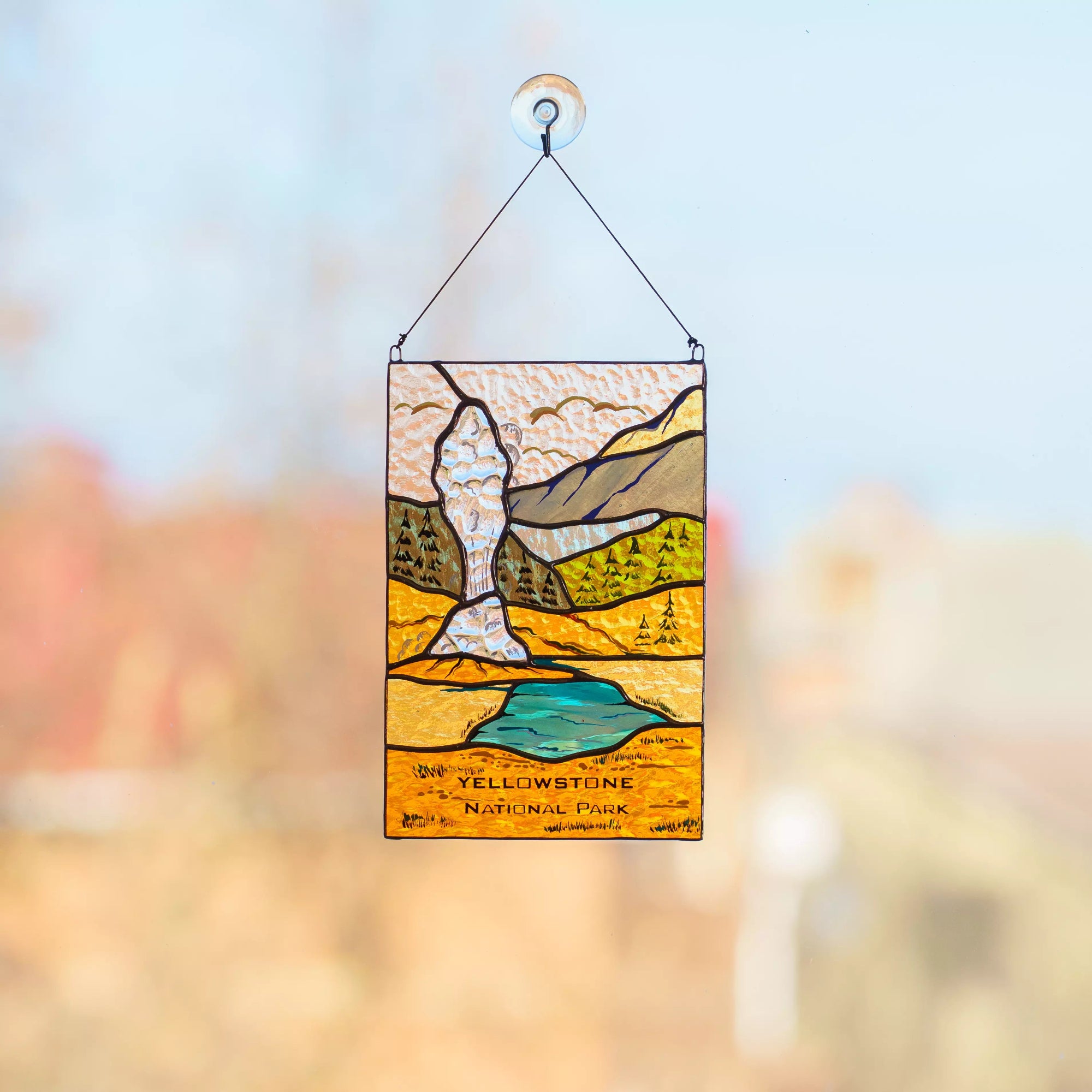 Stained glass panel of Yellowstone National Park with a blurred background