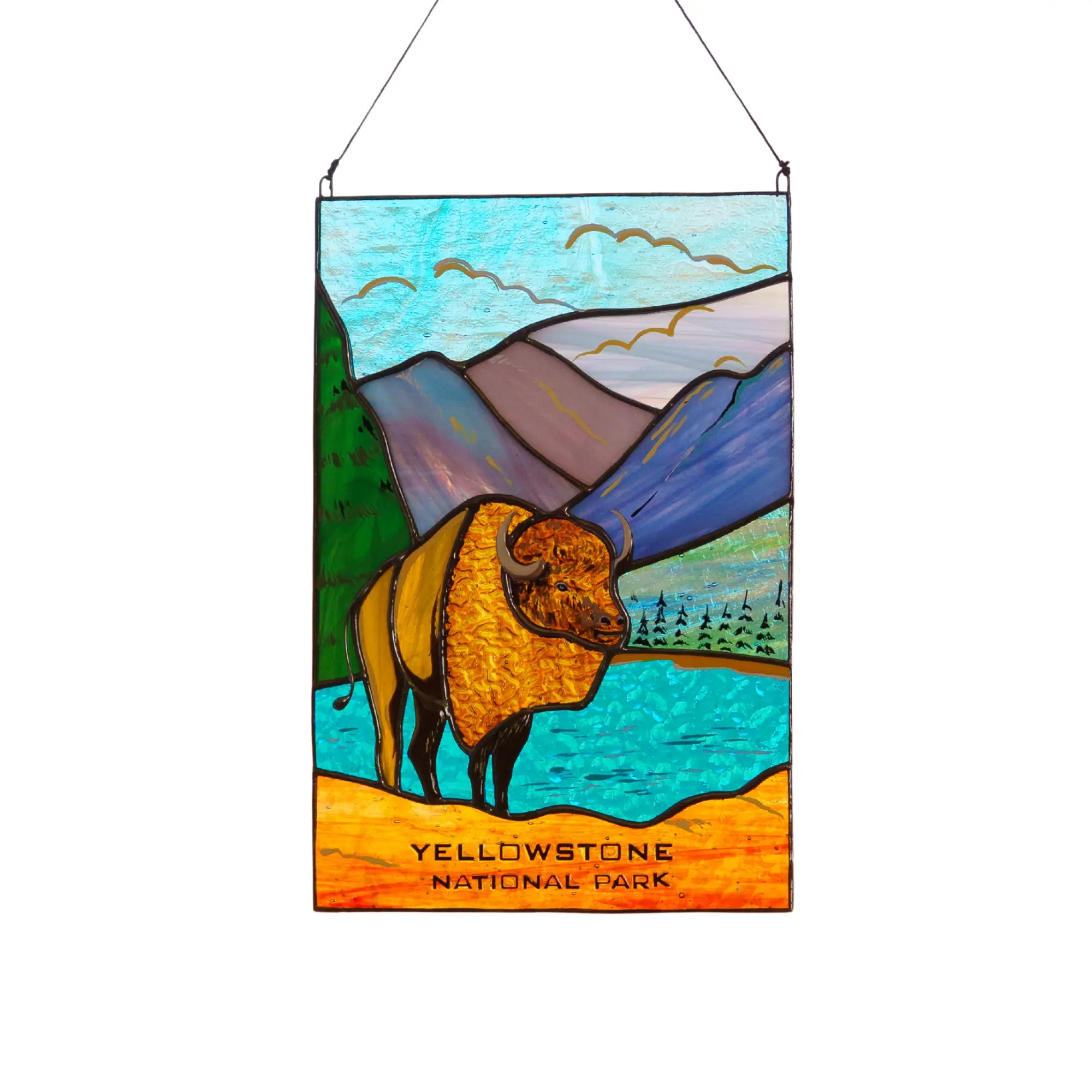 Stained glass panel of a bison in Yellowstone National Park with mountains and water in the background.