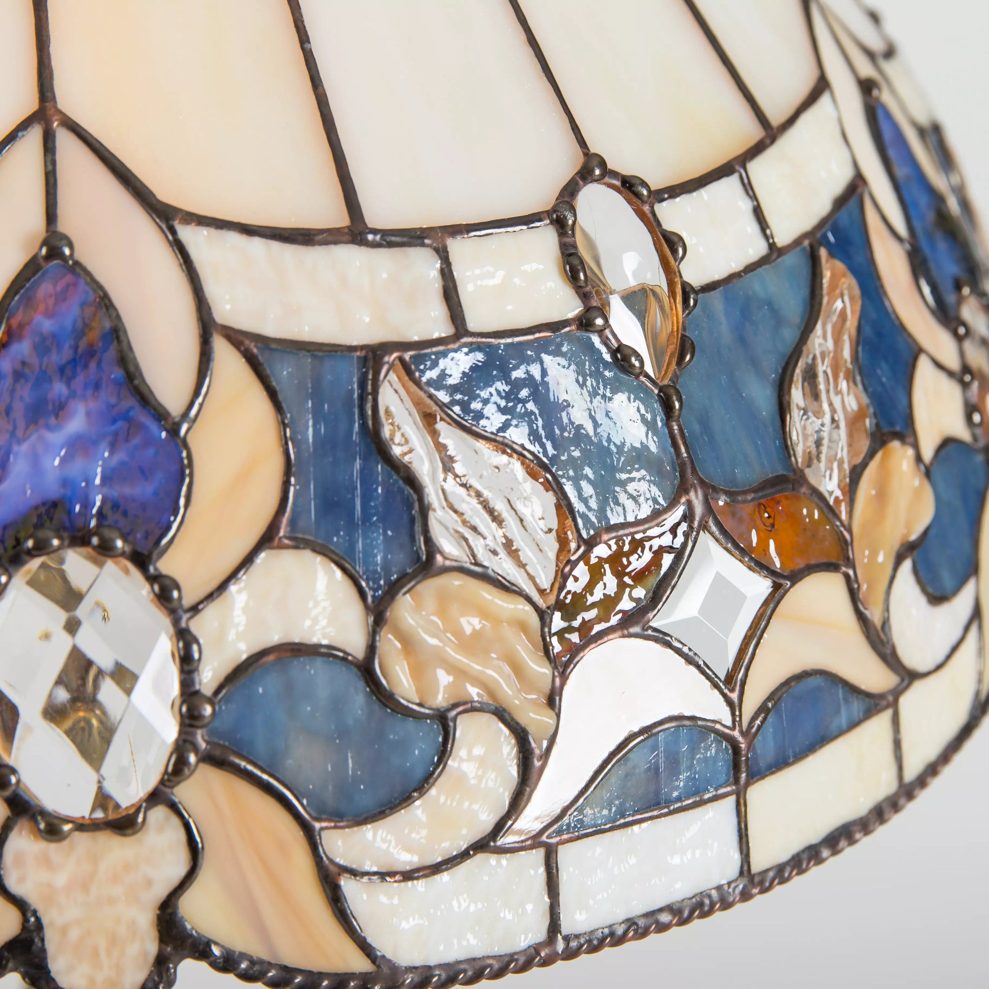 Close-up of intricate floral stained glass pattern with textured and clear glass pieces