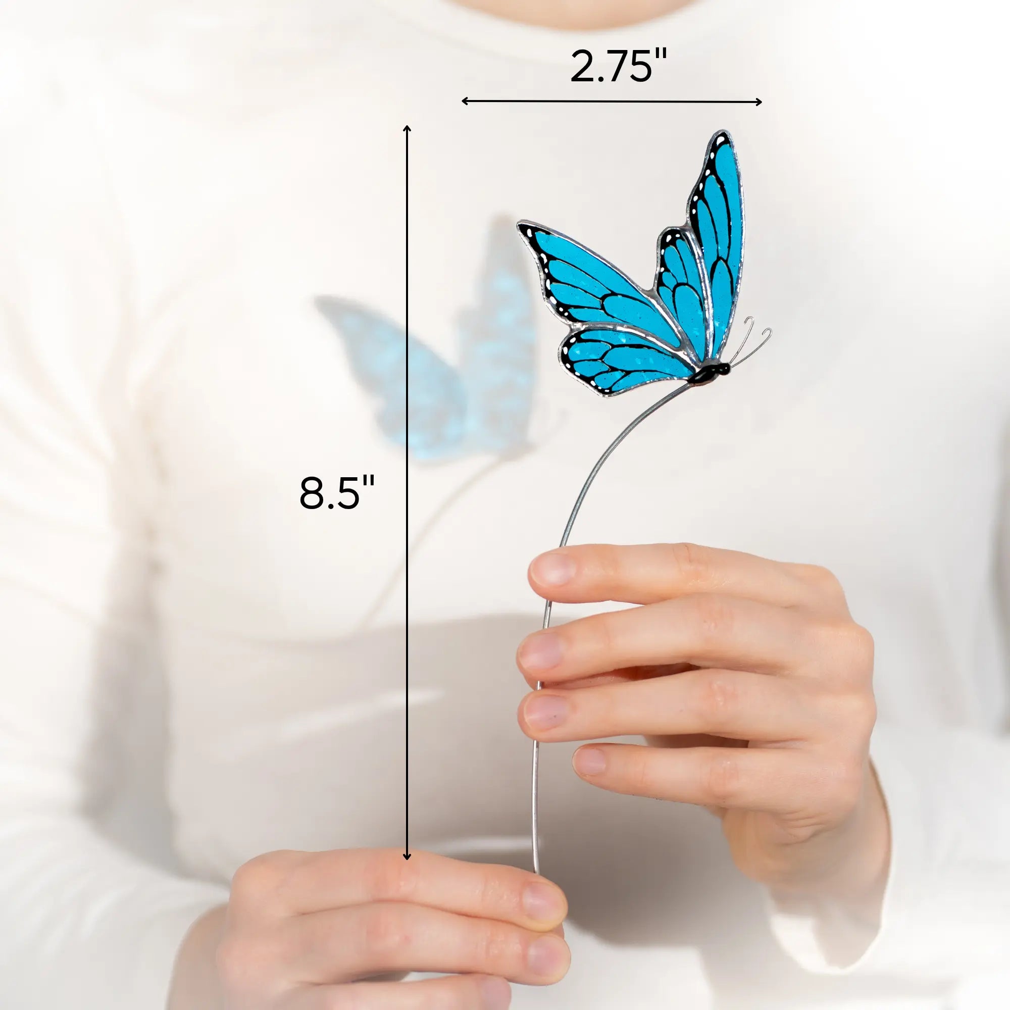 Blue butterfly stained glass item held by a hand with measurements indicated 2.75 x 8.5 inches