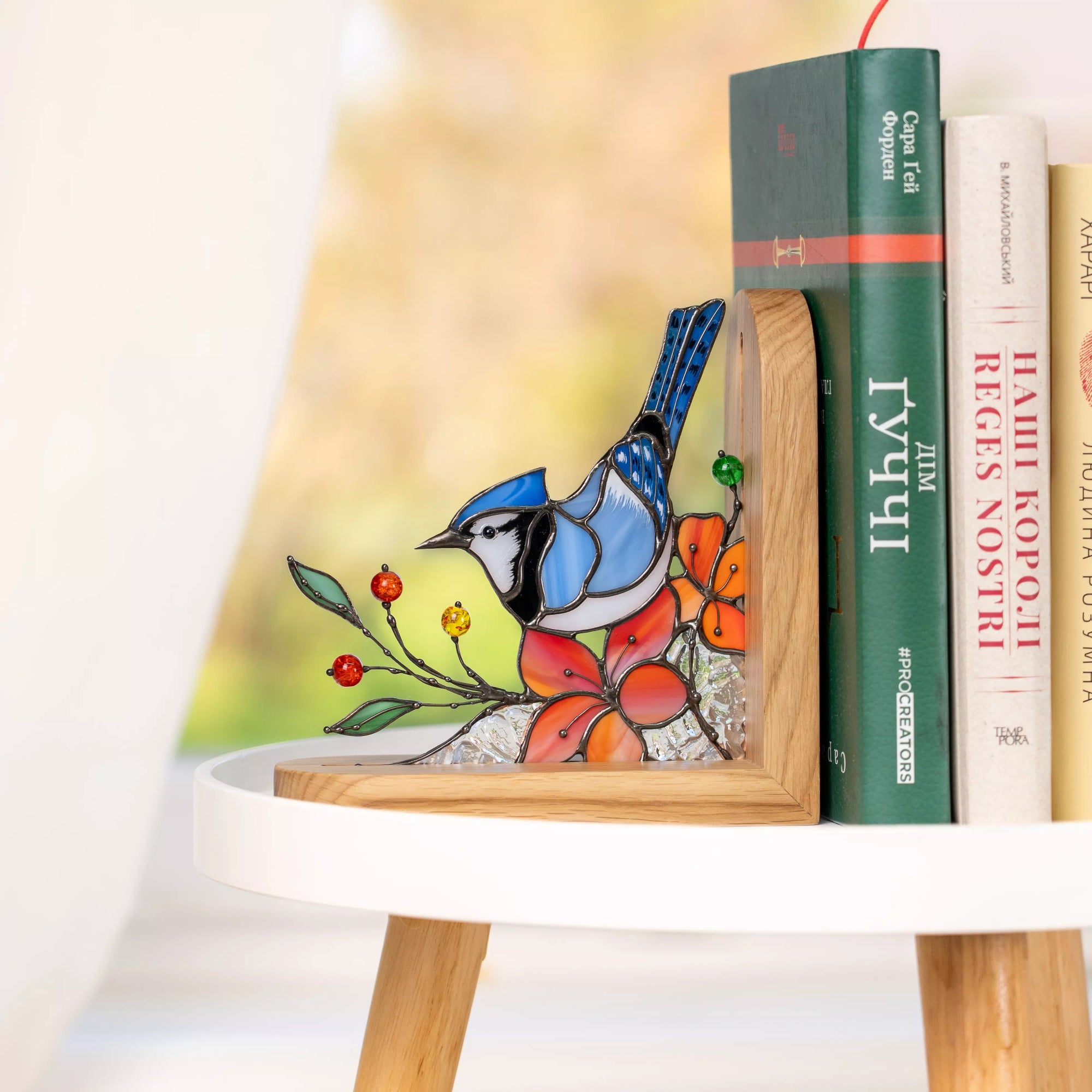 Handmade blue jay stained glass panel used as a decorative bookend.