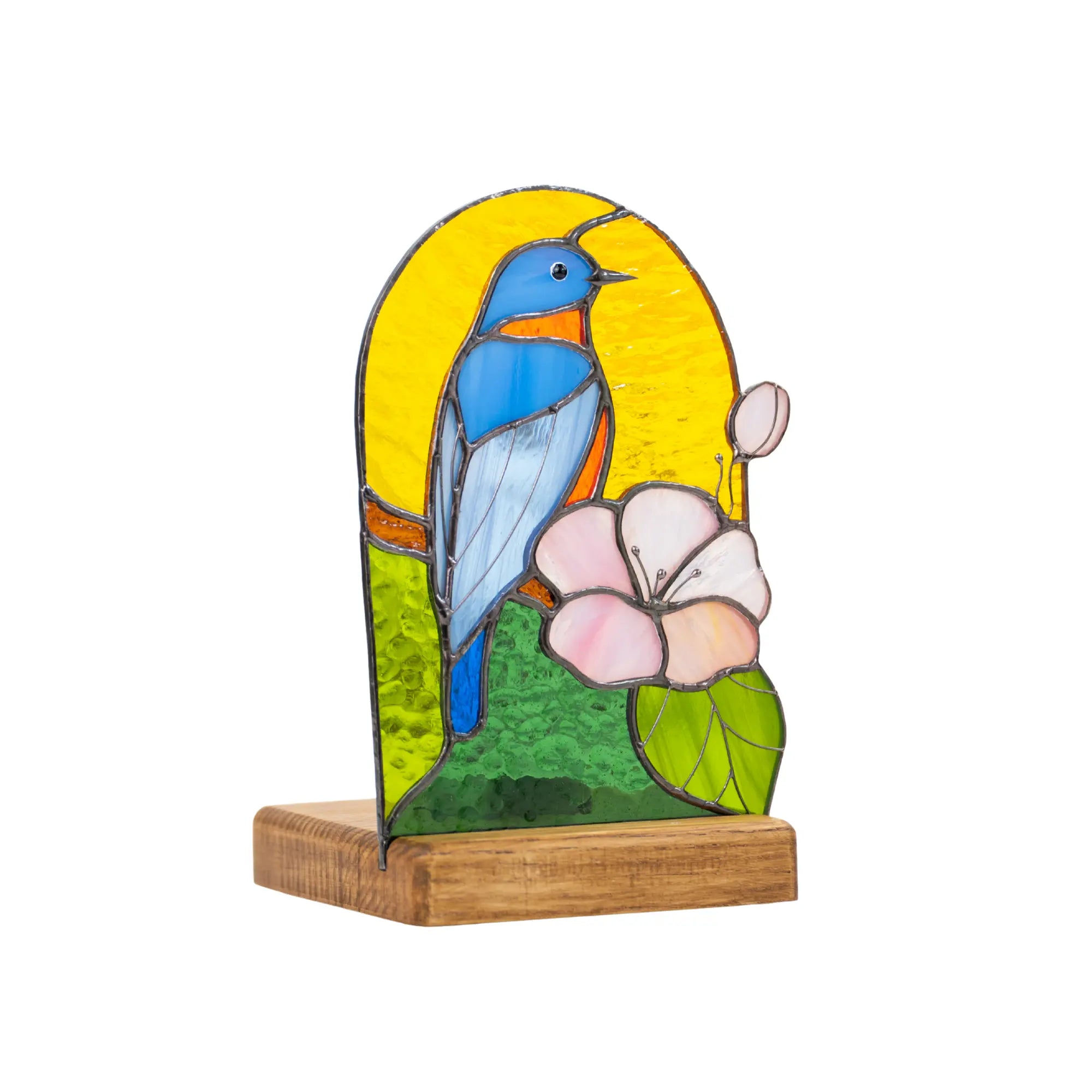 Side view of stained glass candle holder with tealight, bluebird and flower on yellow and green glass