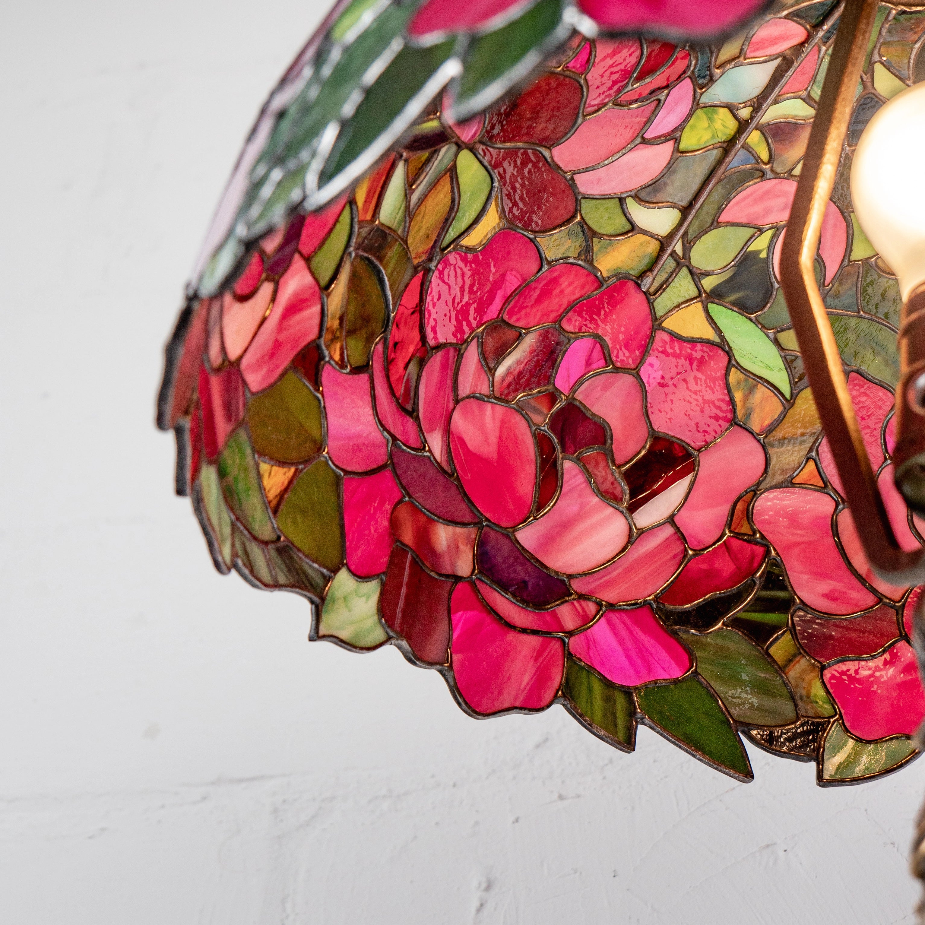 Inside view from bottom showing peony design in stained glass with curved petals and light shining through