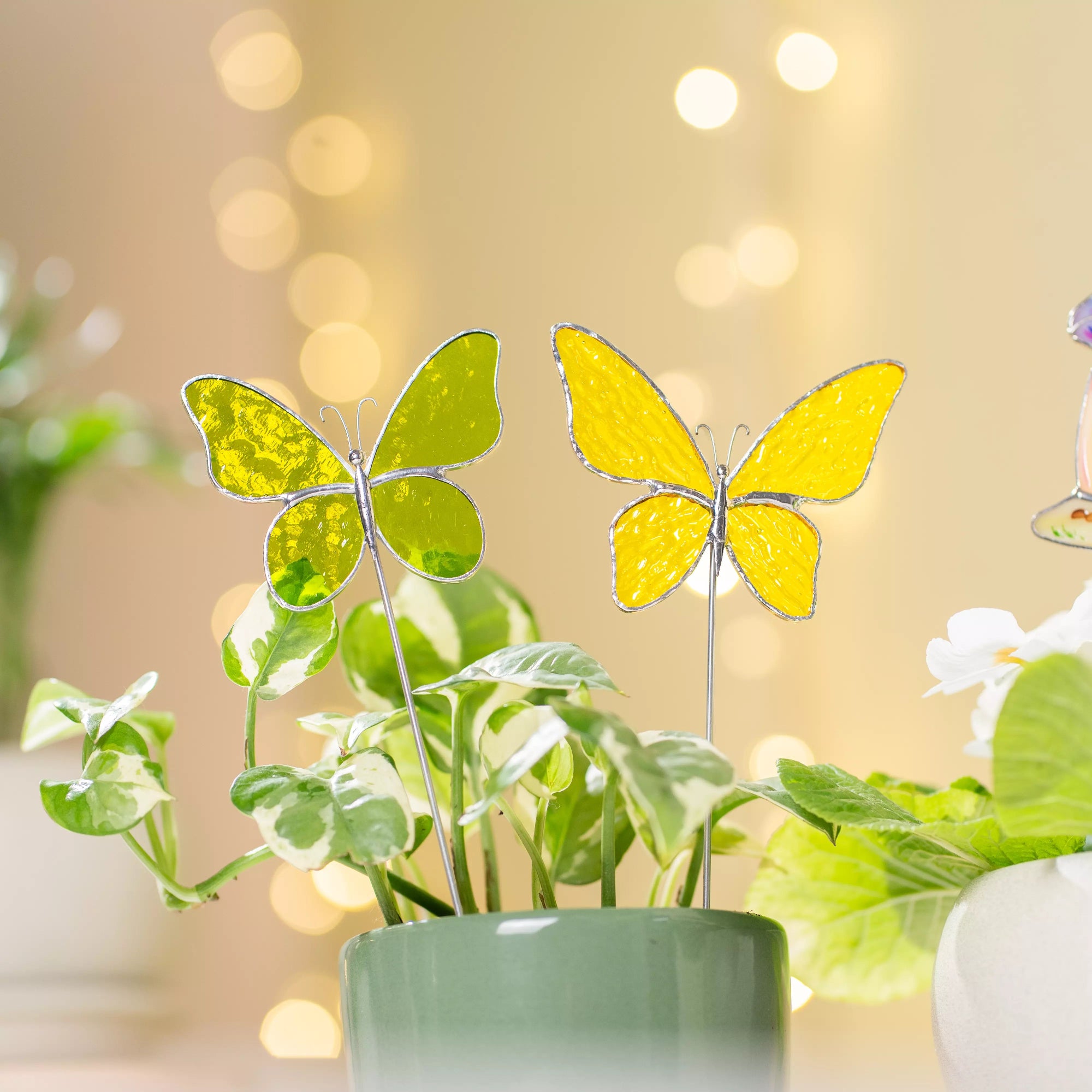Stained glass butterfly plant stakes with a blurred bokeh background