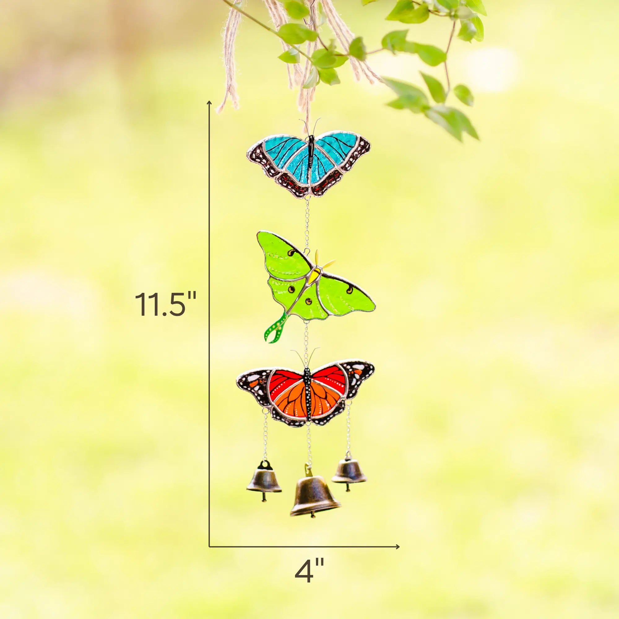 Butterfly-shaped wind chime with bells on a green background