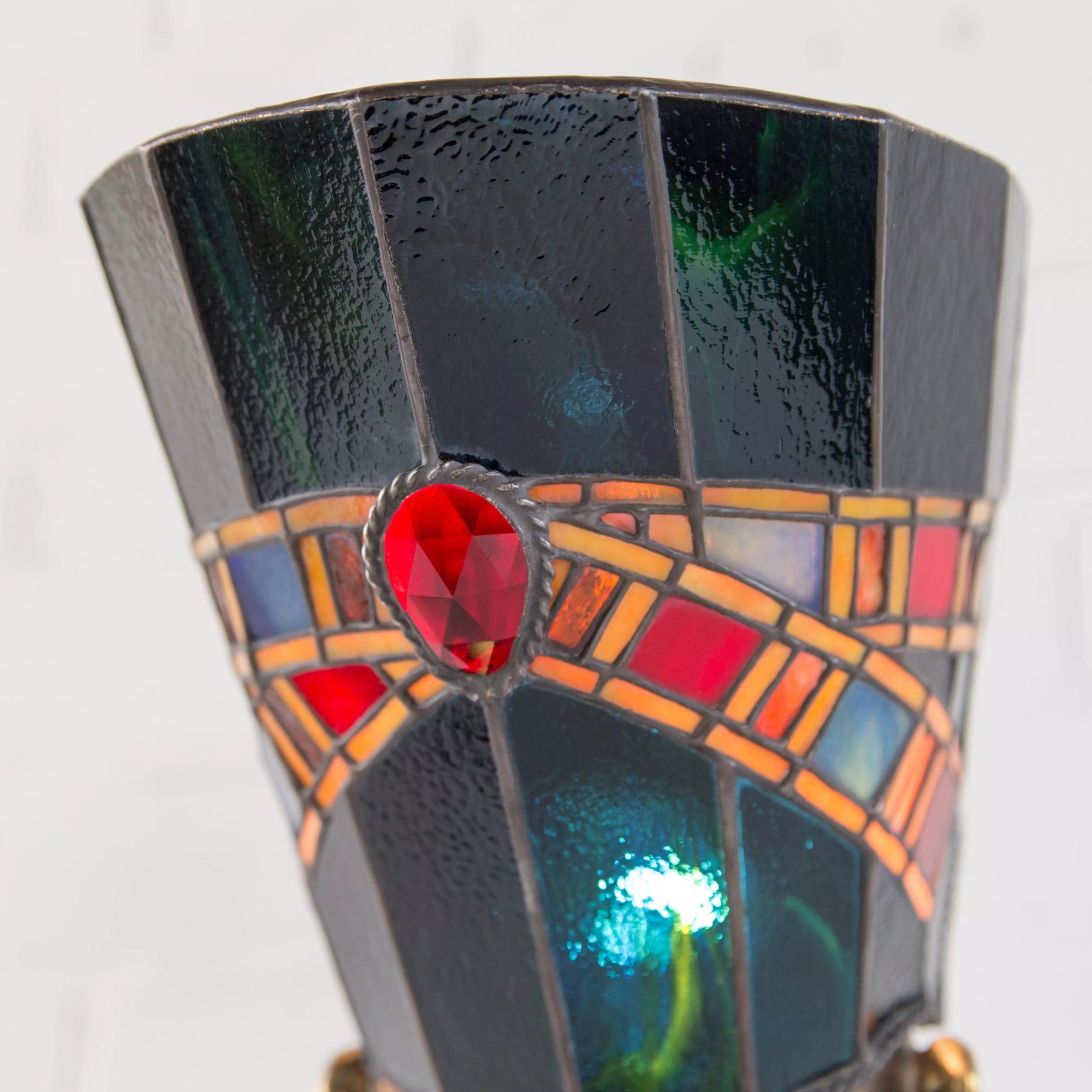 Close-up of back view of stained glass Nefertiti lamp with decorative faceted elements