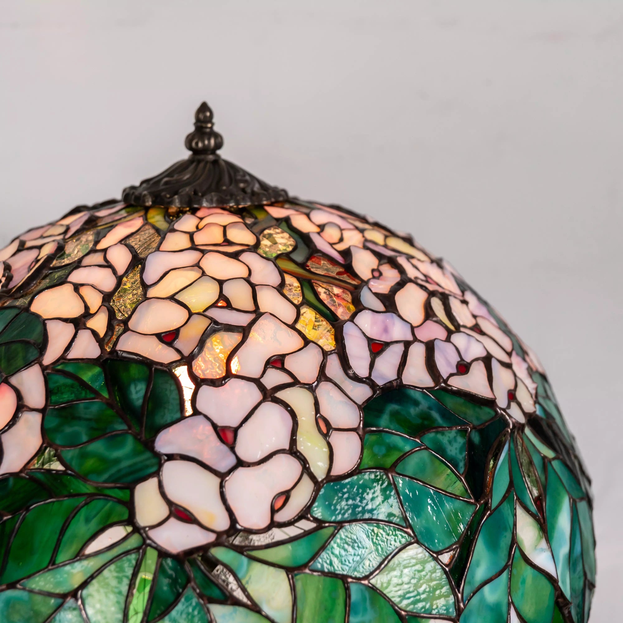 Close view of chestnut stained glass pattern on lamp, showing delicate pink petals and leaves