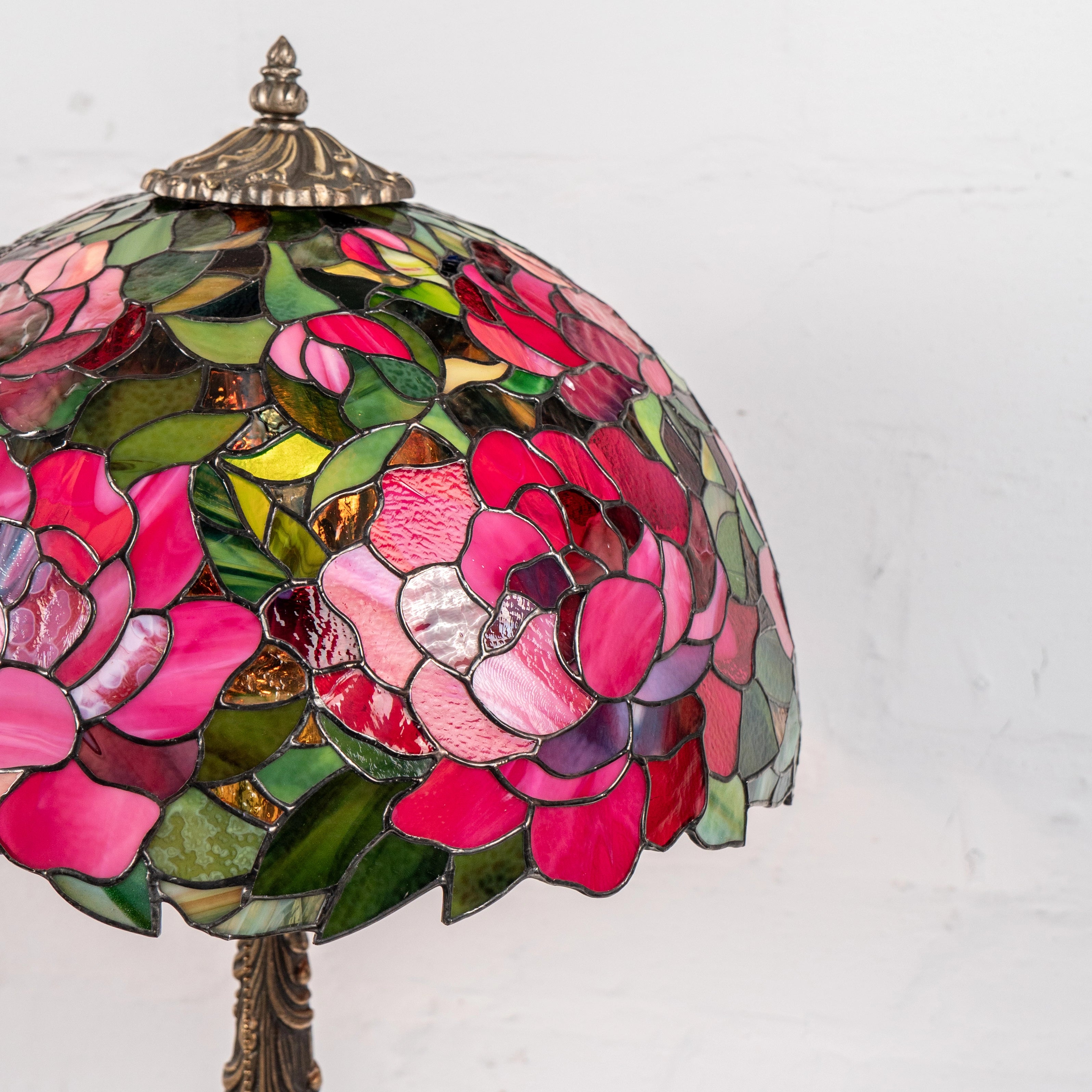 Side view of stained glass lamp with floral design on a white background
