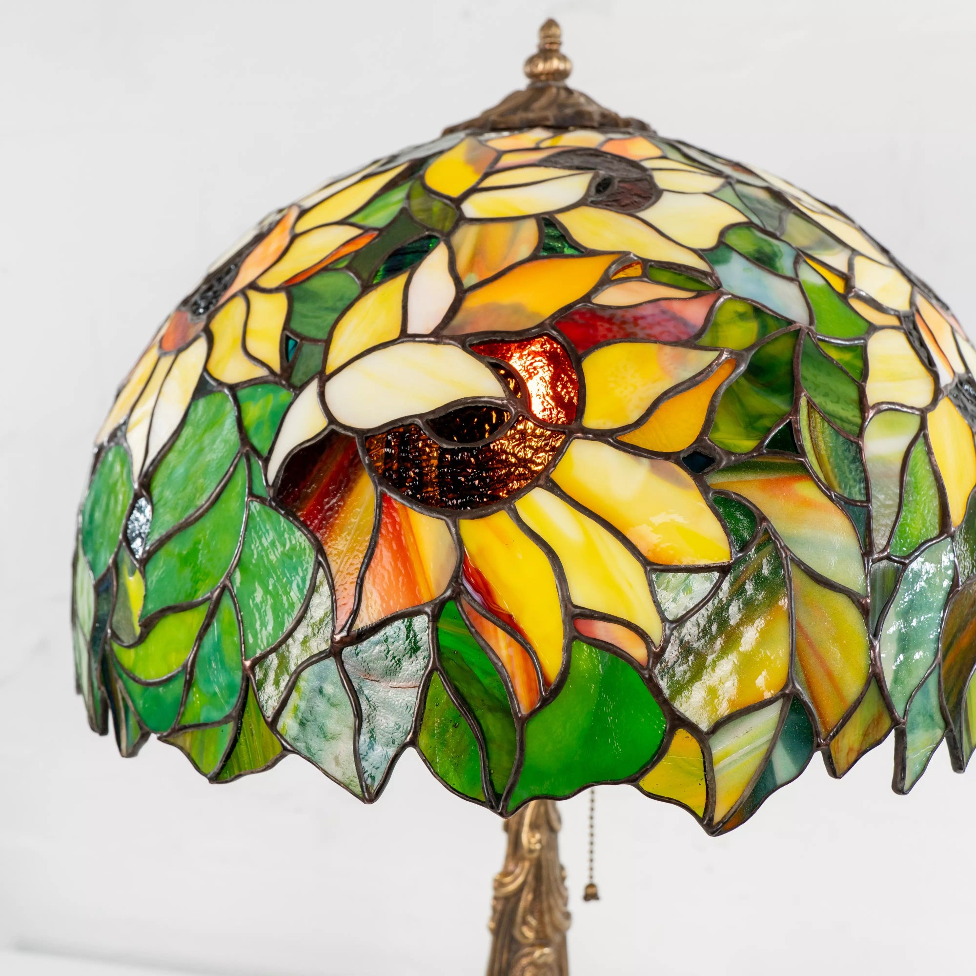 Detailed view of stained glass sunflower petals and leaves in vibrant colors