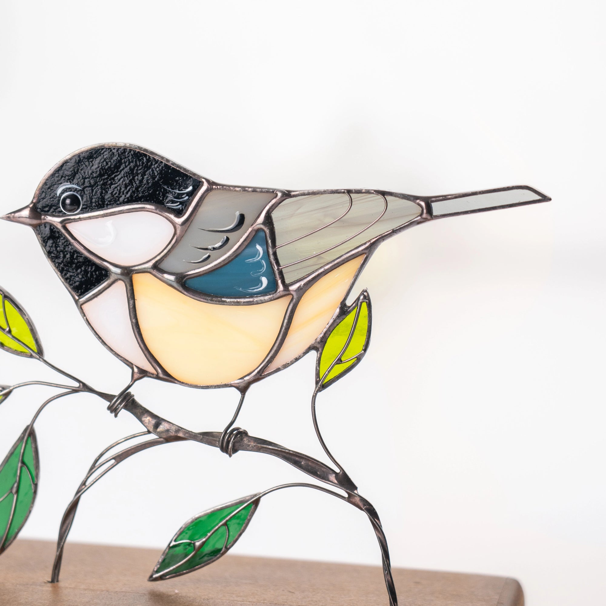 Detailed view of chickadee stained glass suncatcher with curved metalwork