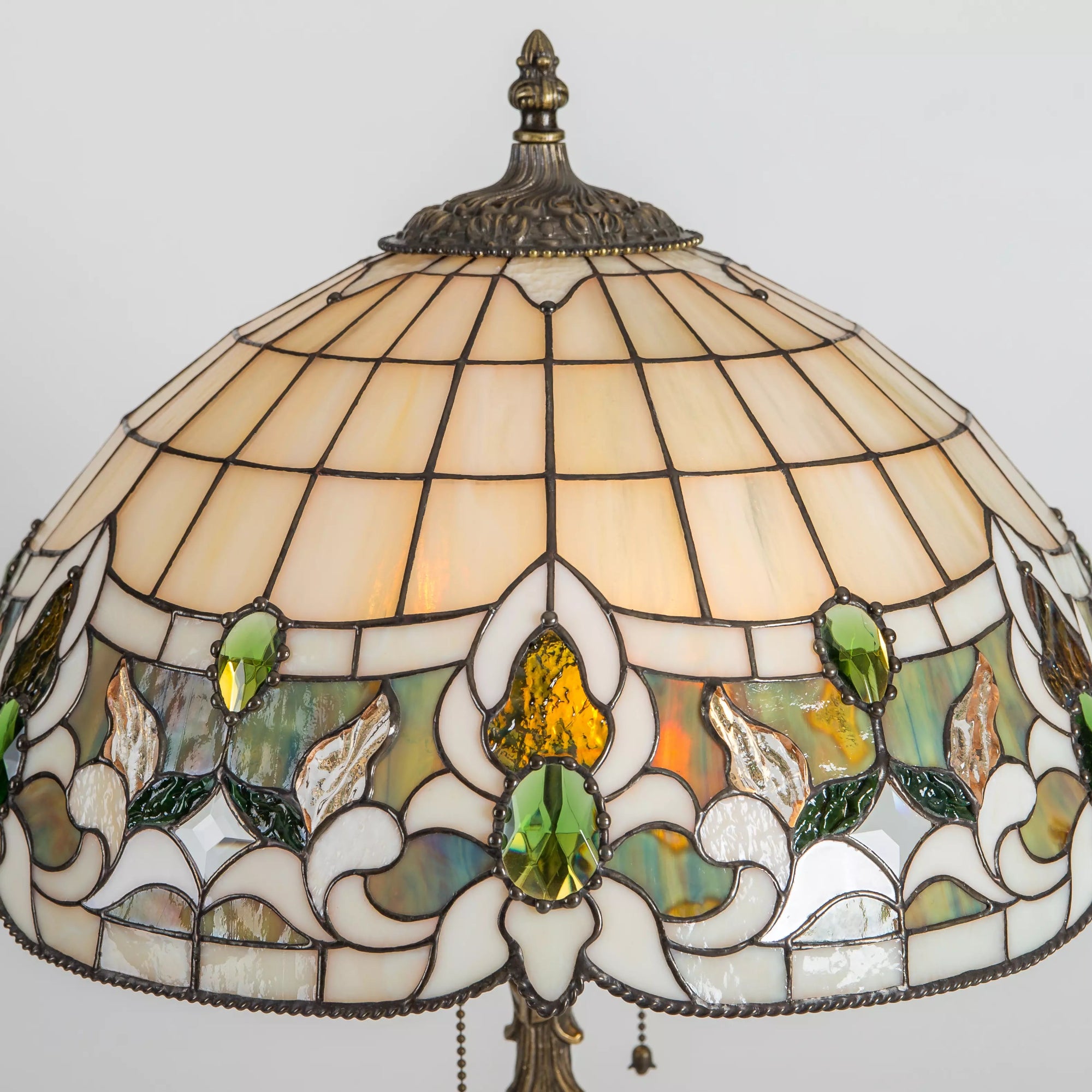 Detailed stained glass floral design with green gems, amber textures, and decorative soldering
