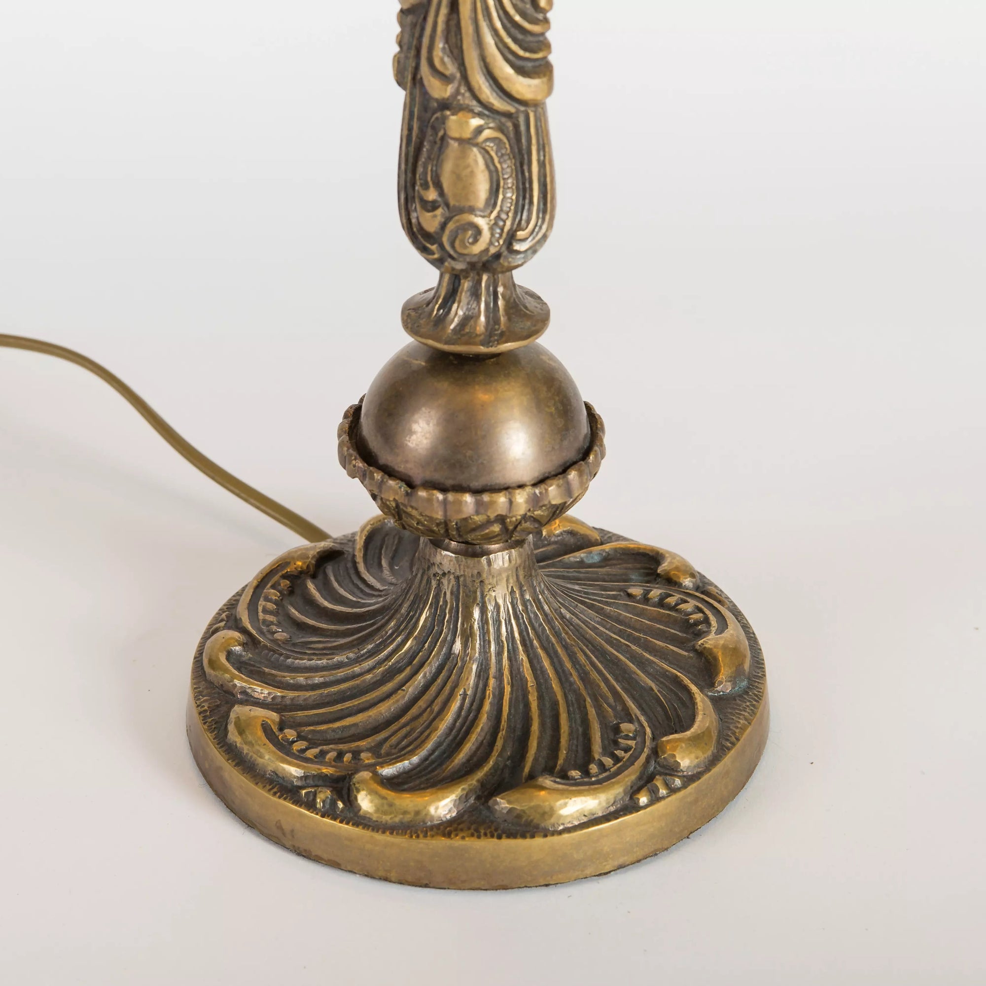 Closeup of the textured bronze-tone base of the stained glass table lamp