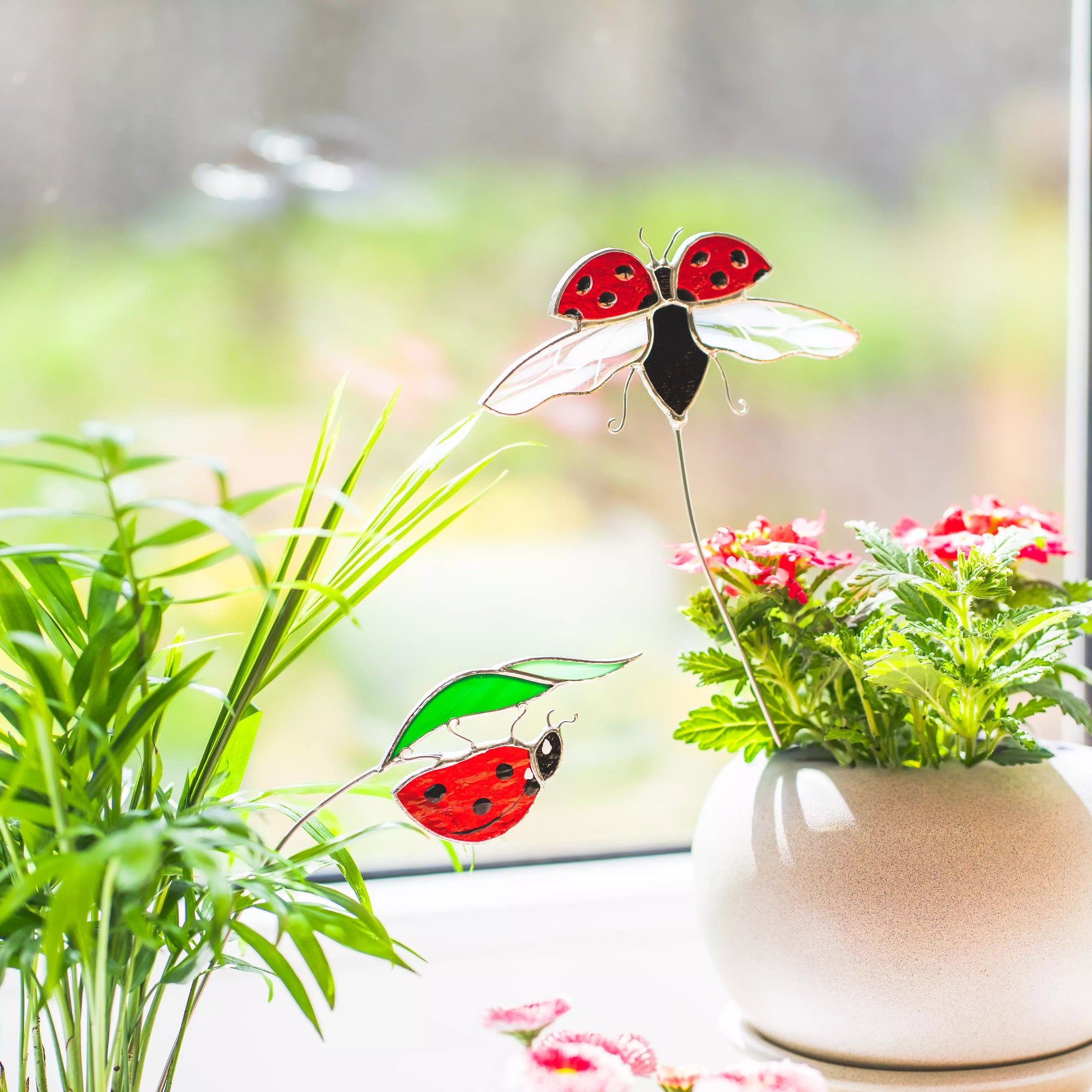 Stained glass ladybug on a plant with a blurred natural background