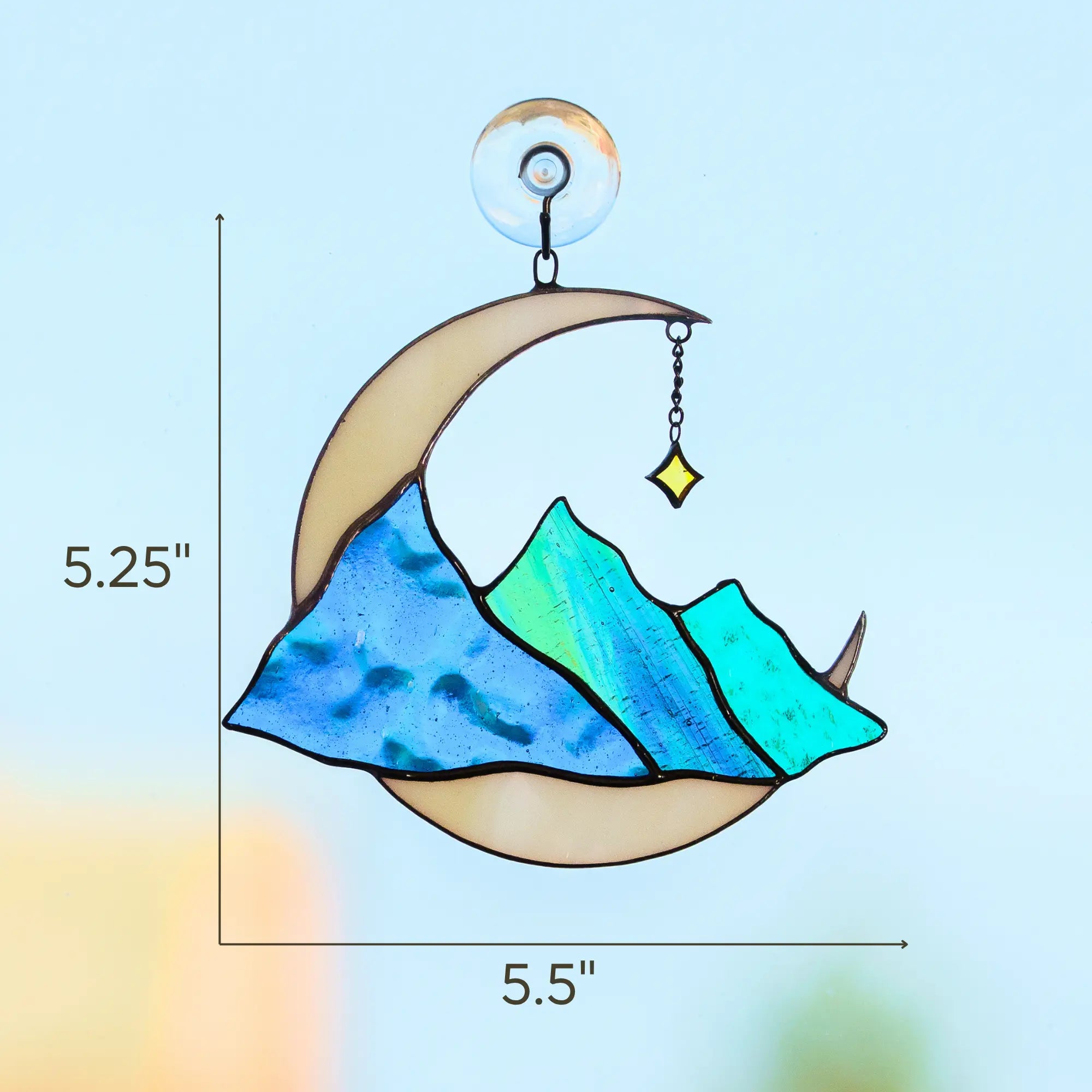 Decorative stained glass moon with mountain design and measurements on a light blue background: 5.25 x 5.5 inches