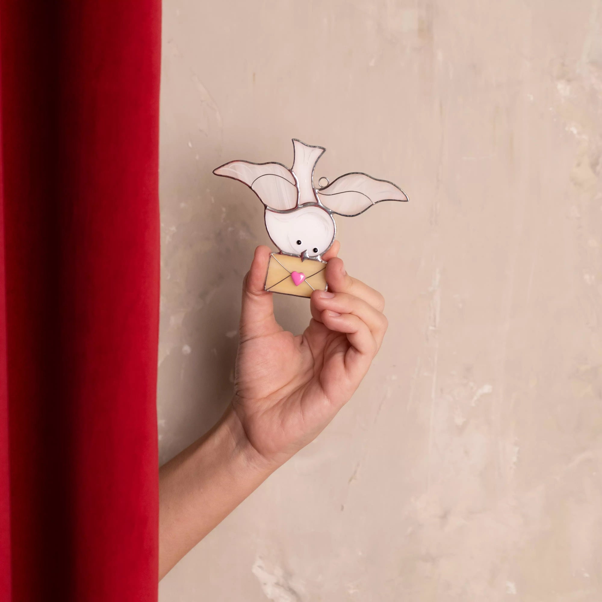 Dove stained glass suncatcher held in one hand to show size and fine details