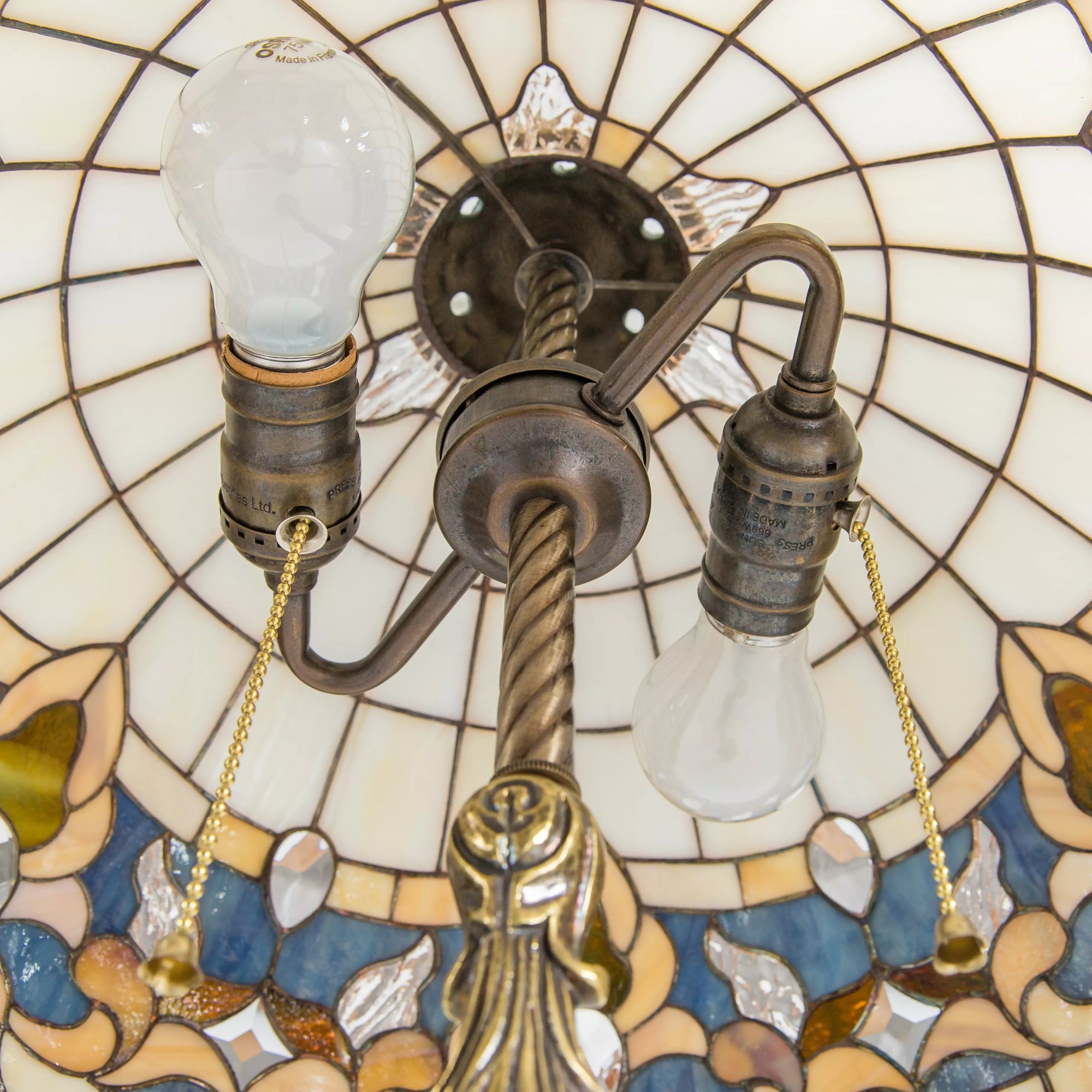 Inside view of lamp showing bulb sockets, pull chains, and stained glass shade from below