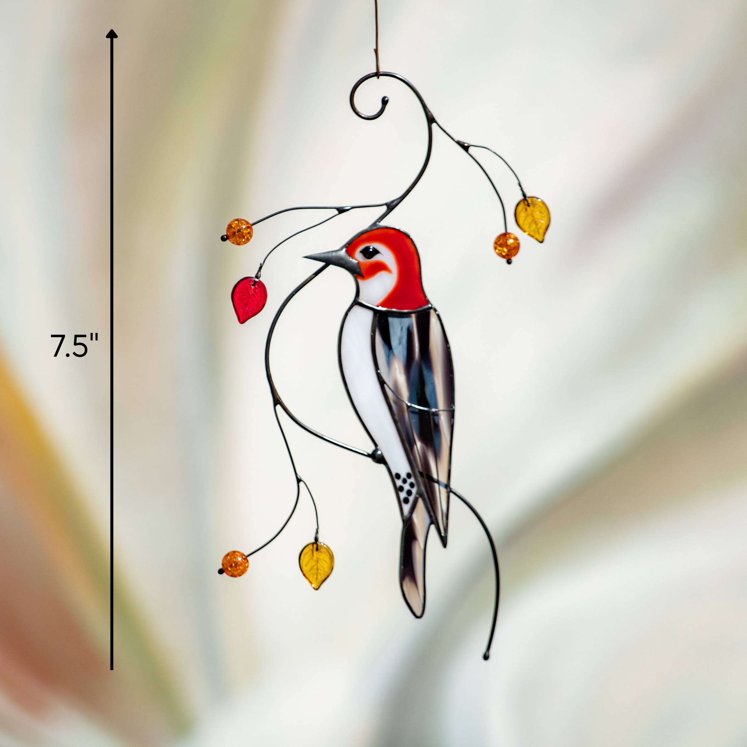Vertical stained glass woodpecker decor measured at 7.5 inches, hanging with glass leaves on artistic wire.