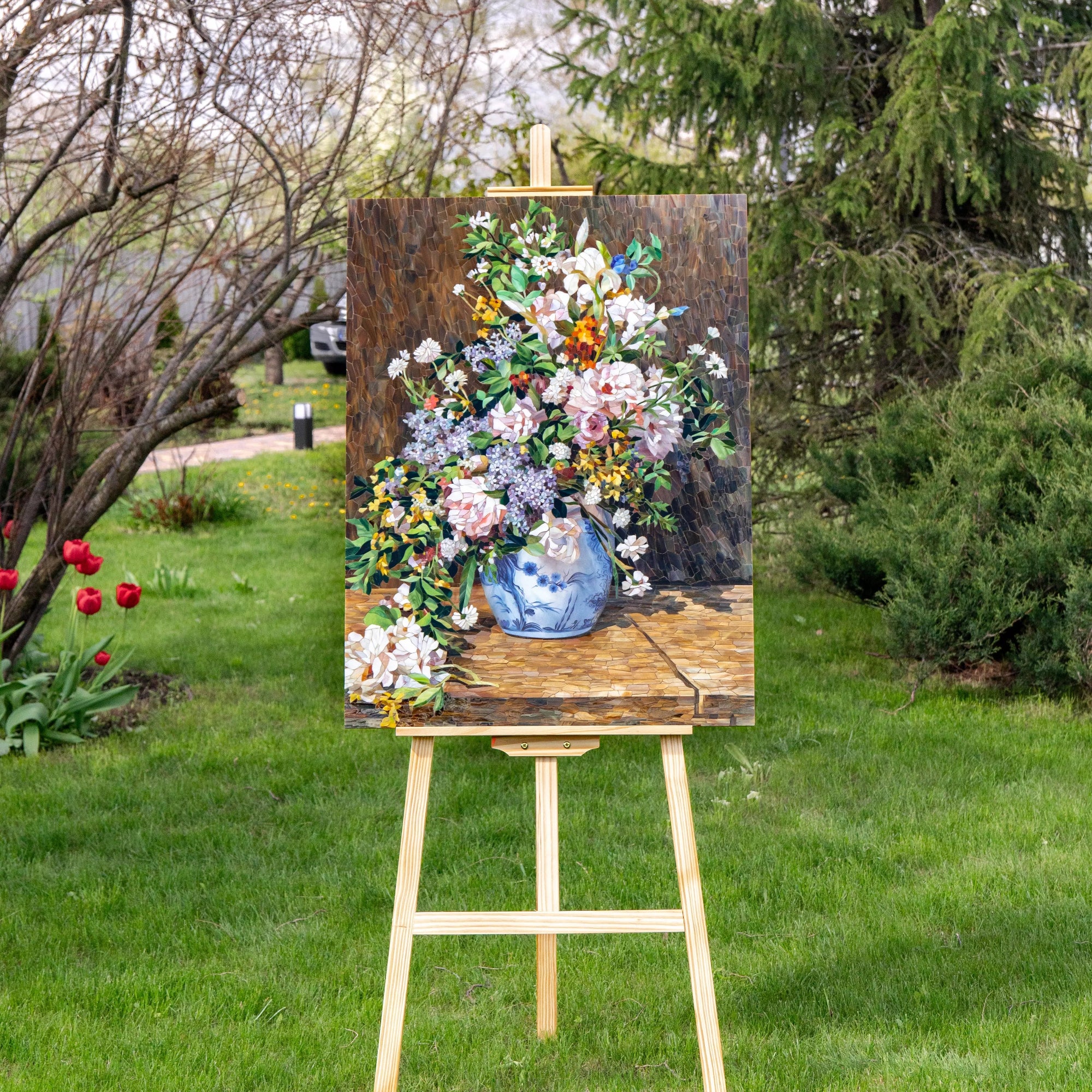 Floral painting inspired by Spring Bouquet on an easel outdoors with greenery in the background