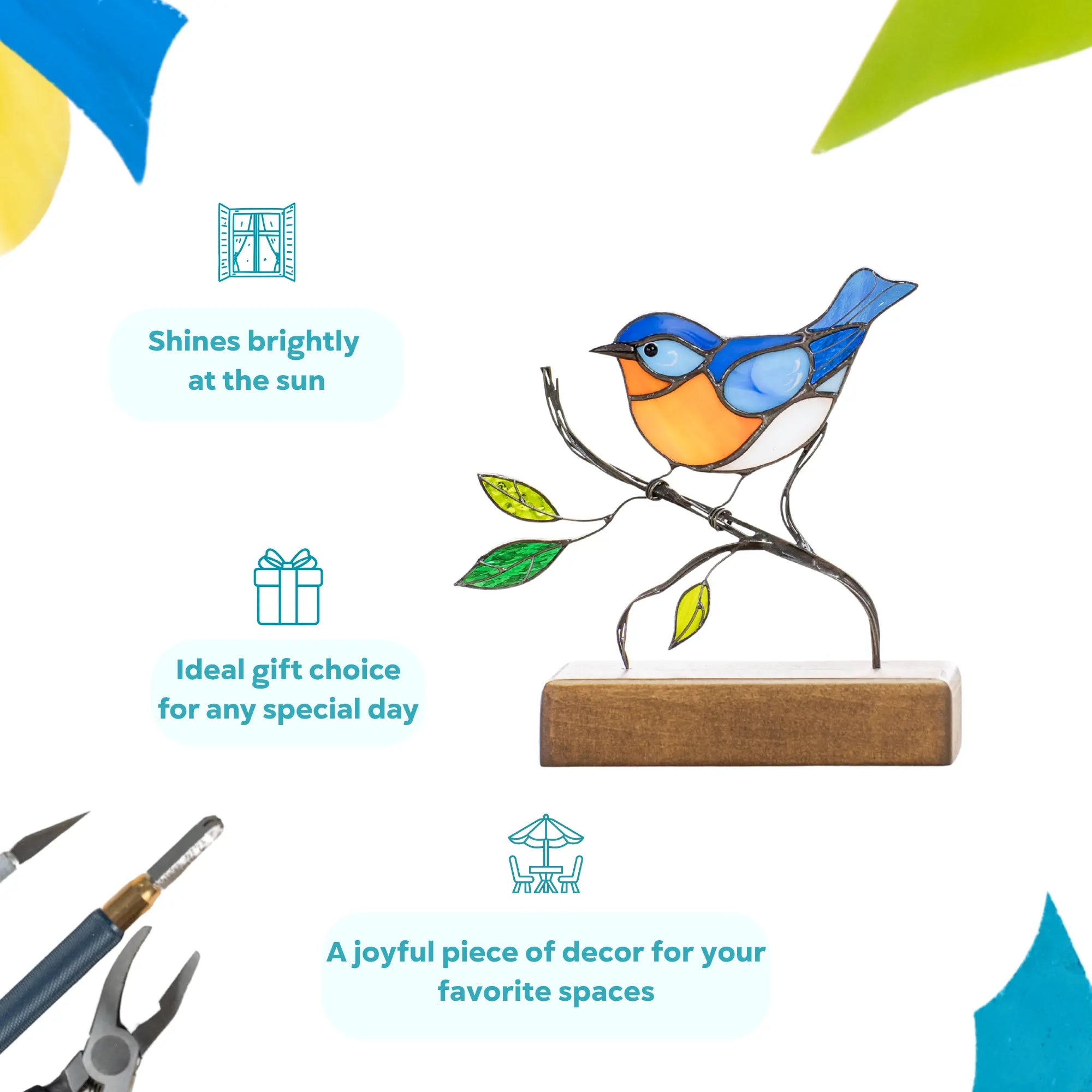 Colorful stained glass bluebird perched on branch with green glass leaves, mounted on a display base