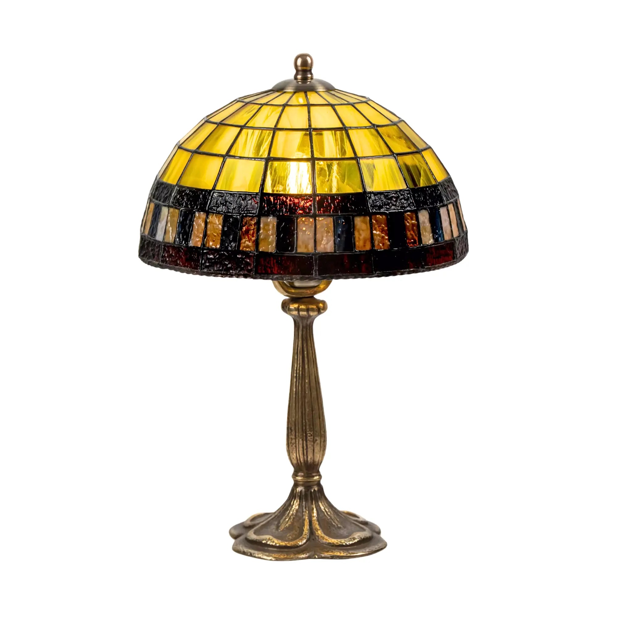 Stained glass lamp lit on white background with geometric yellow panels and bold mosaic band
