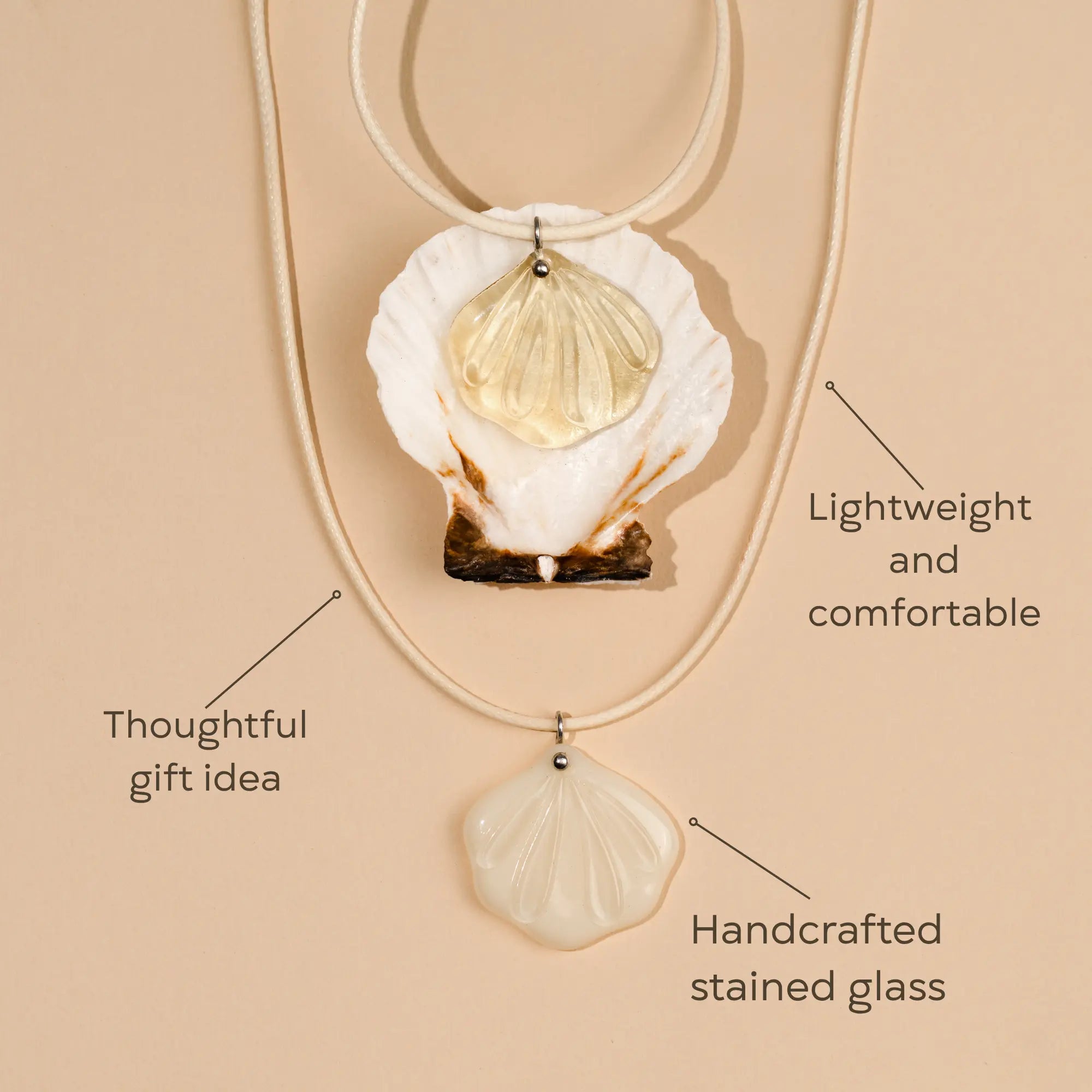 Shell-shaped pendant necklace with handcrafted stained glass on a beige background as a thoughtful gift idea