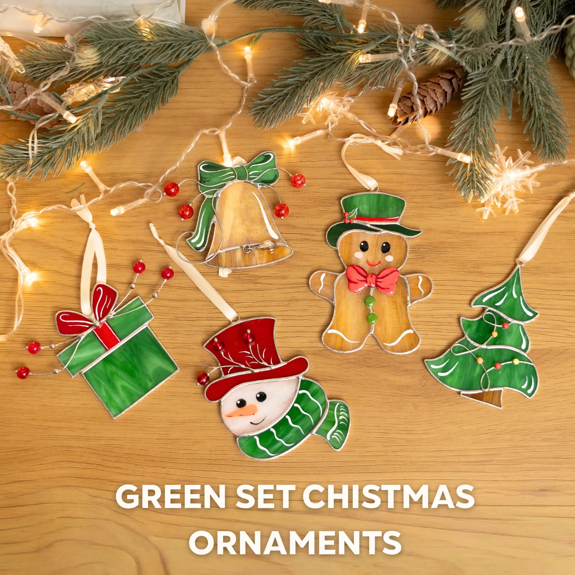 Set of Christmas ornaments including a bell, gingerbread man, snowman, and tree on a wooden surface with lights and greenery.