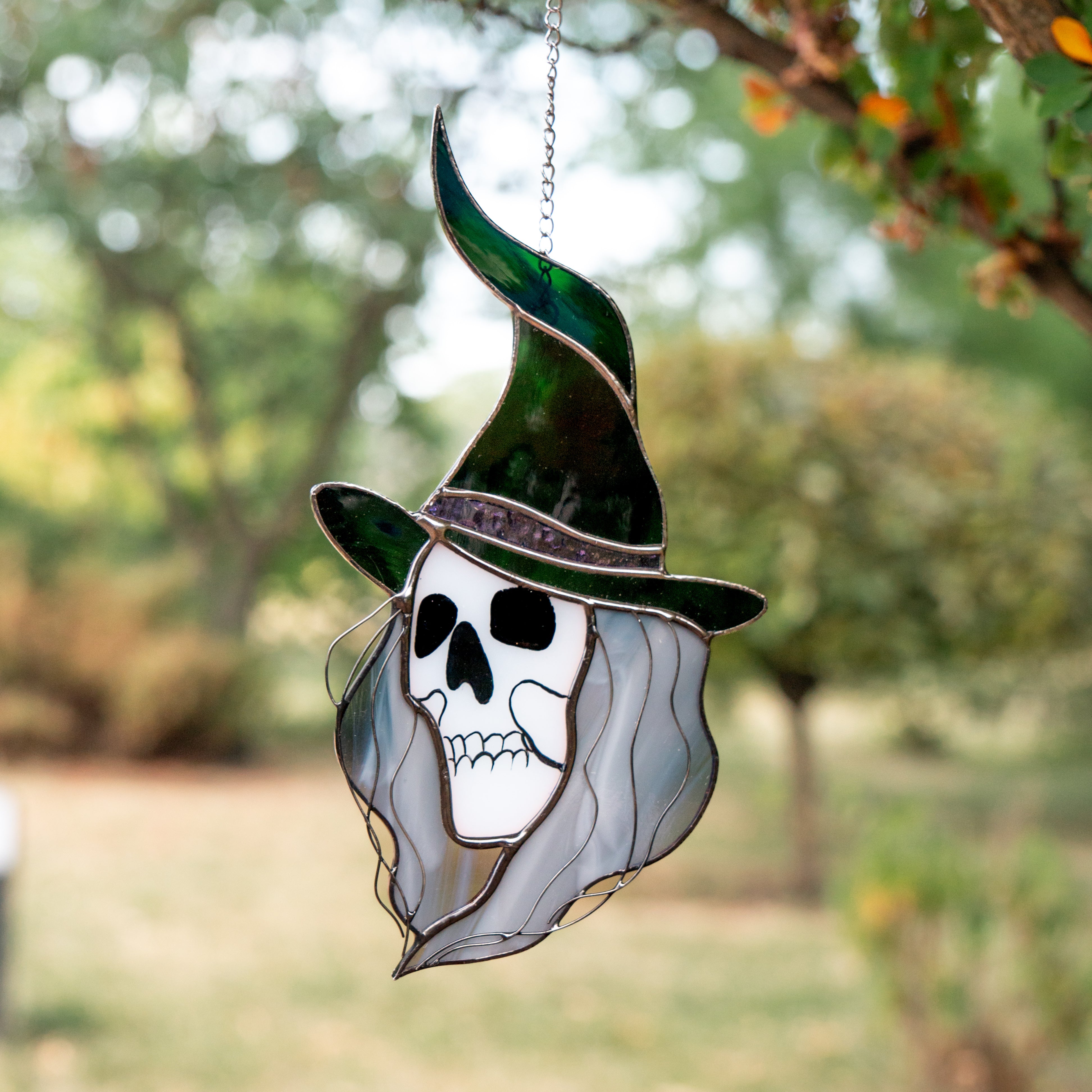Suncatcher featuring Grey Witch hanging in green foliage at the garden