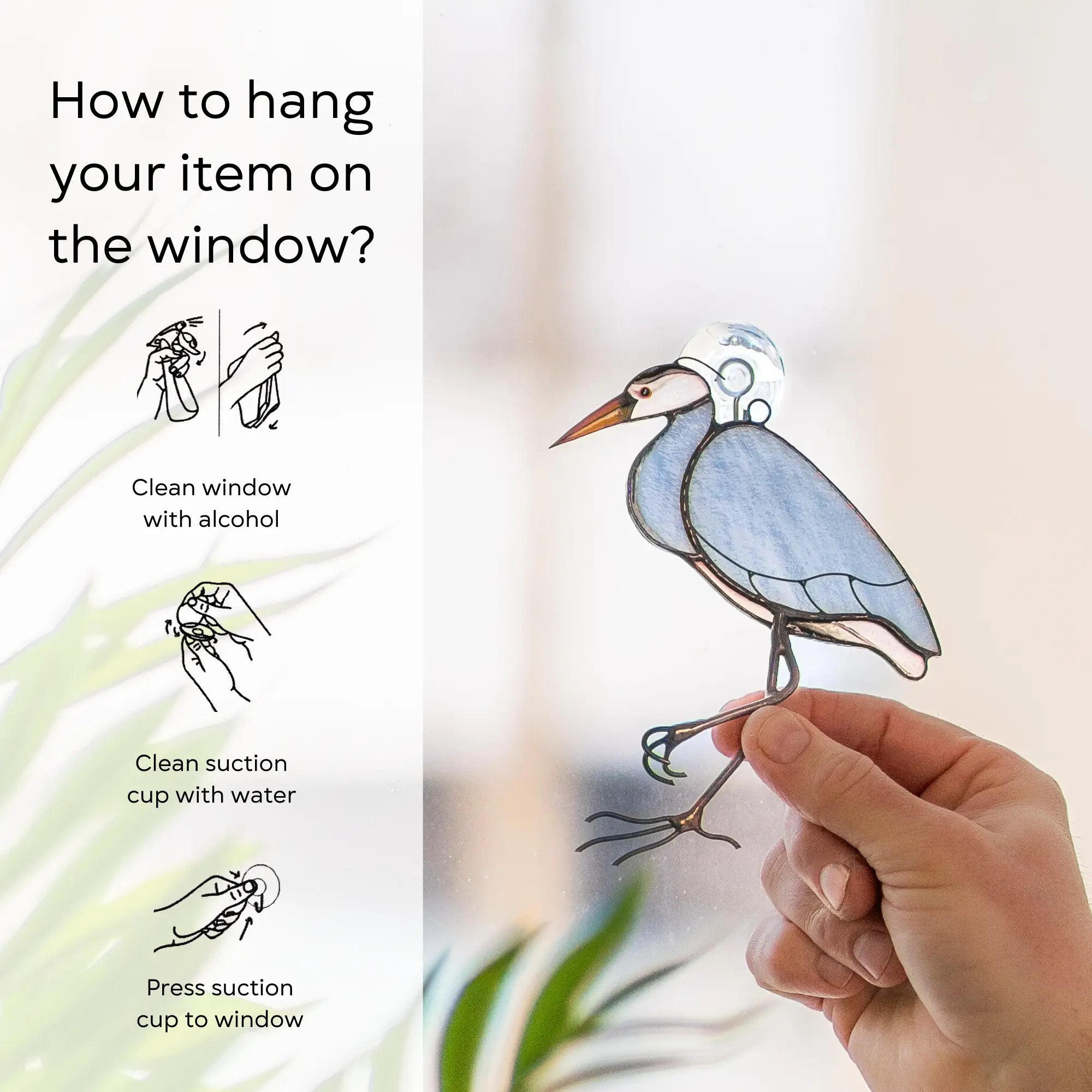 Hand holding a stained glass heron near a suction cup with instructions on how to hang it on a window: clean window and suction cup, press a cup to the surface