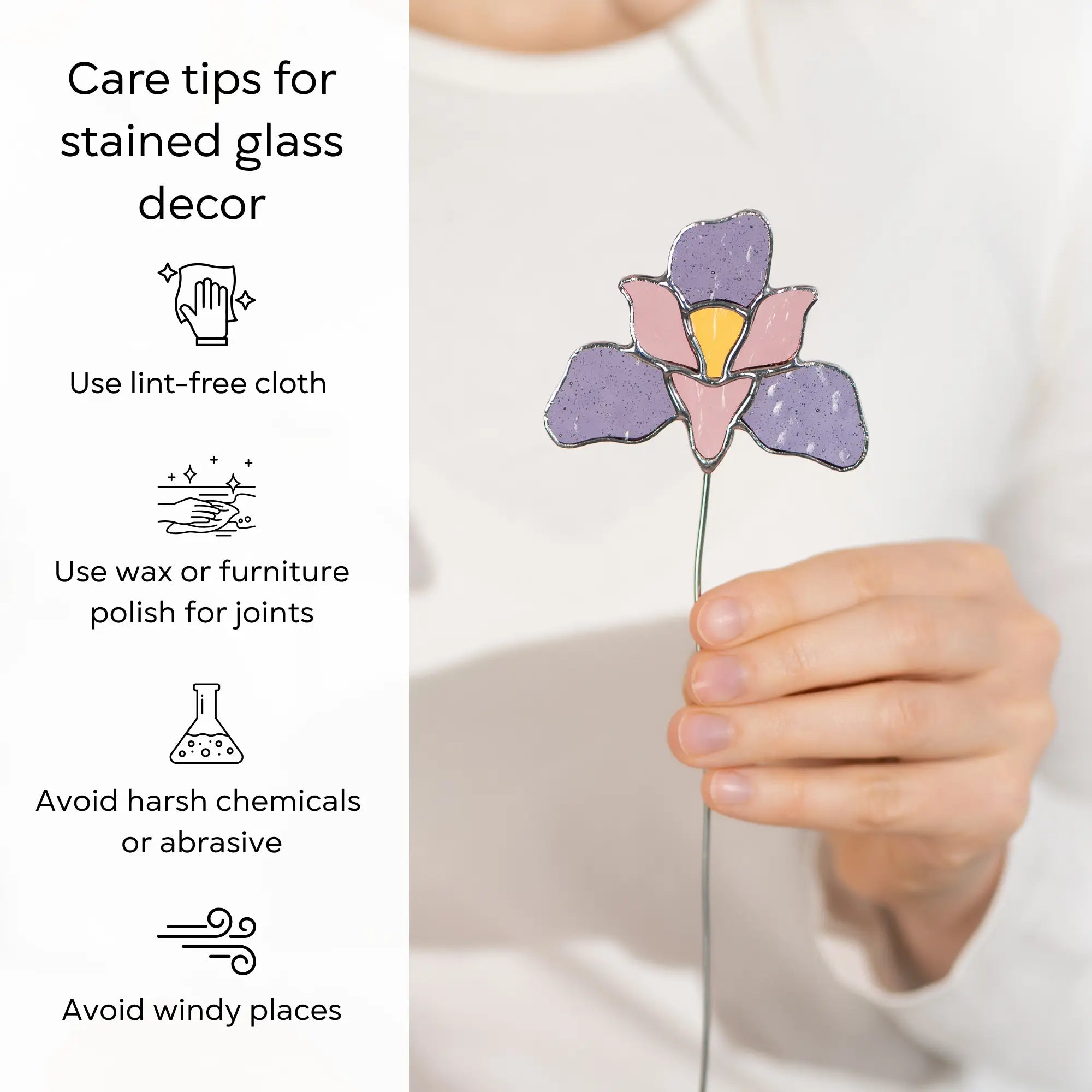 Hand holding a stained glass iris flower plant stake with care tips on the left side: use lint-free cloth, polish joints with car wax or furniture polish, avoid harsh chemicals, and windy places.