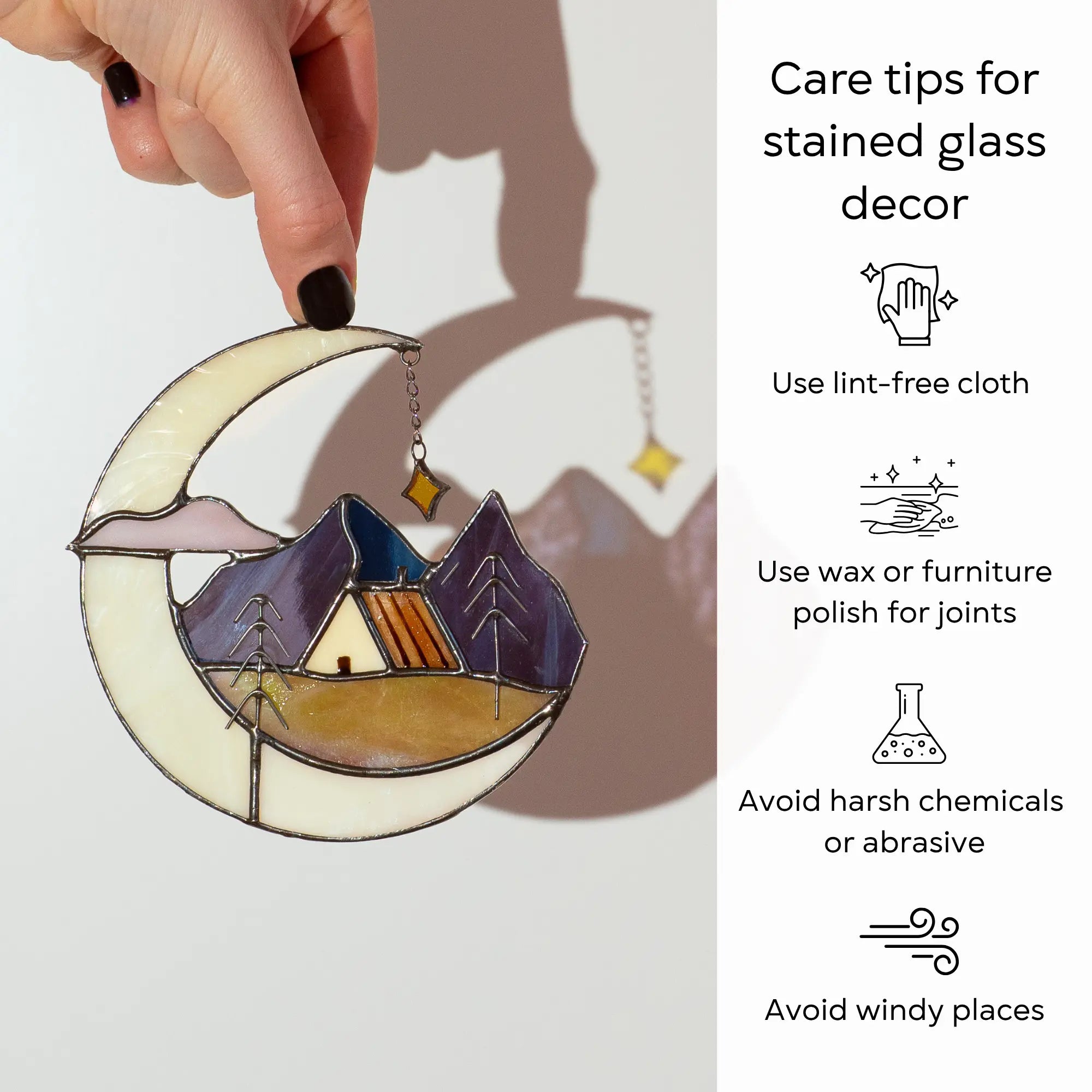 Hand holding stained glass moon celestial suncatcher with care tips beside: use lint-free cloth, polish joints with car wax or furniture polish, avoid harsh chemicals, and windy places.