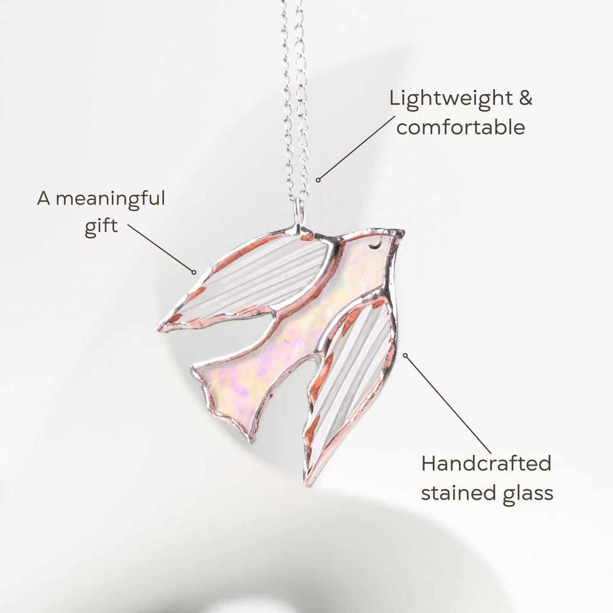Handcrafted stained glass bird pendant on necklace on a white background