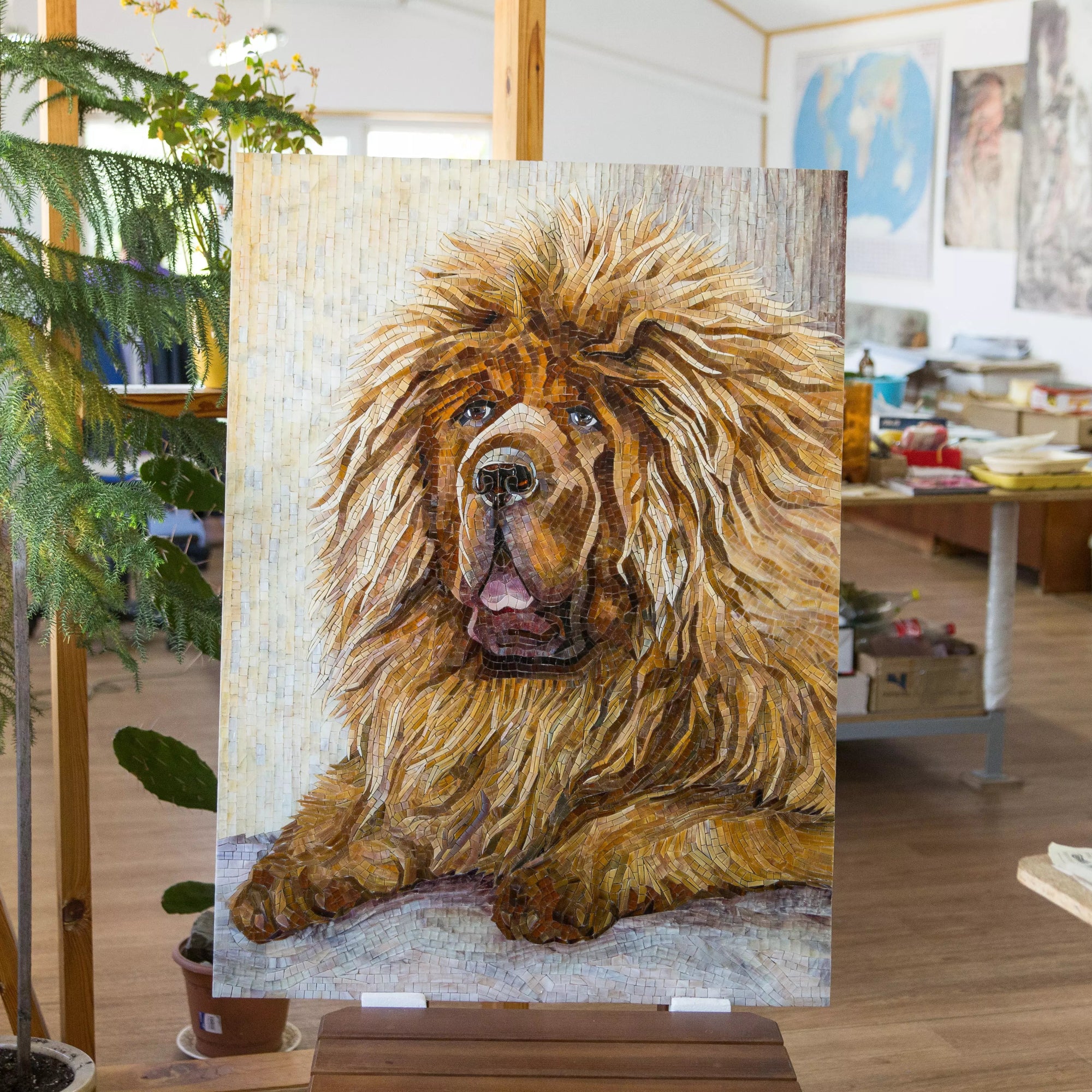 Vertical mosaic of a majestic Tibetan Mastiff surrounded by plants and artwork in an artist’s studio