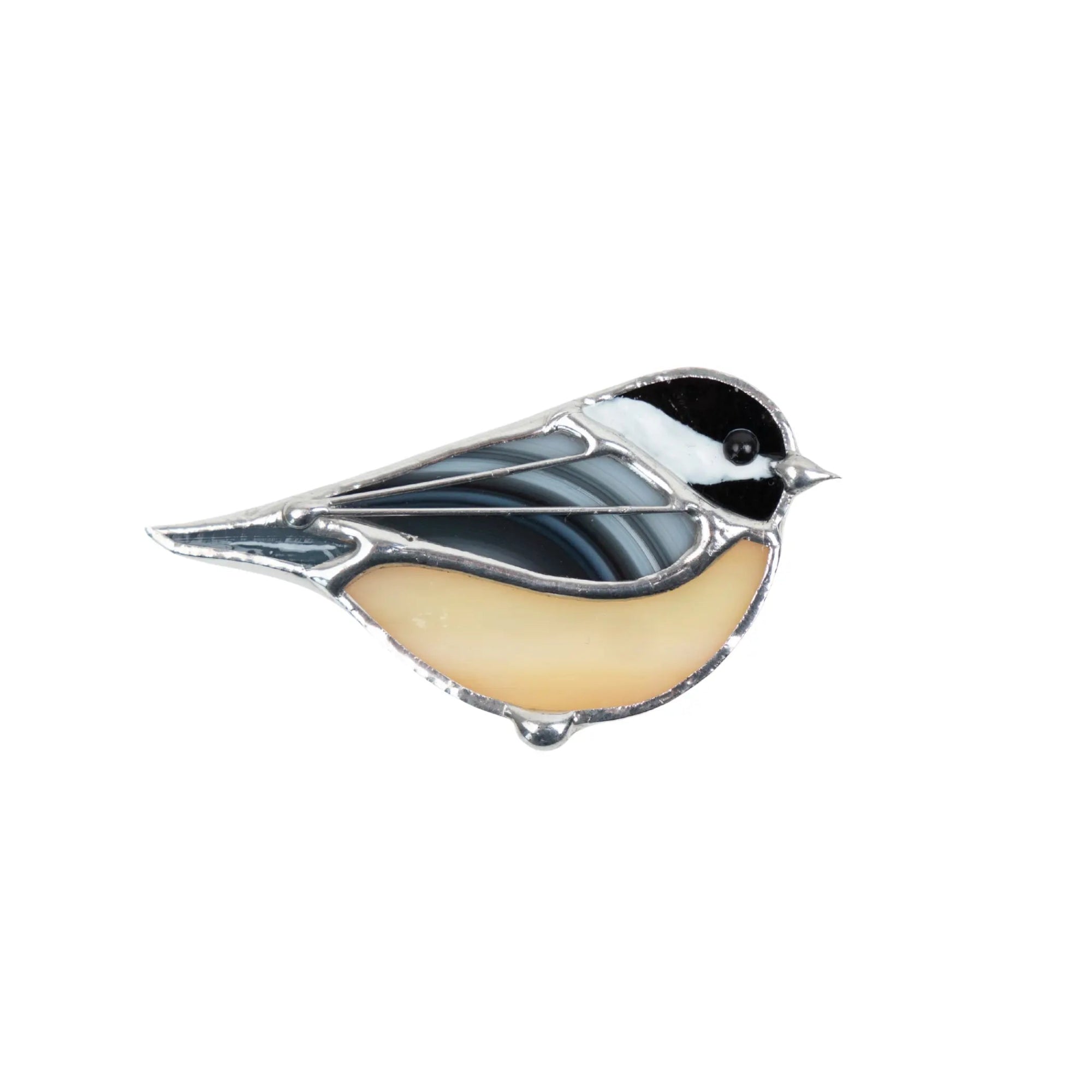 Chickadee brooch made of stained glass with cream and black glass sections.