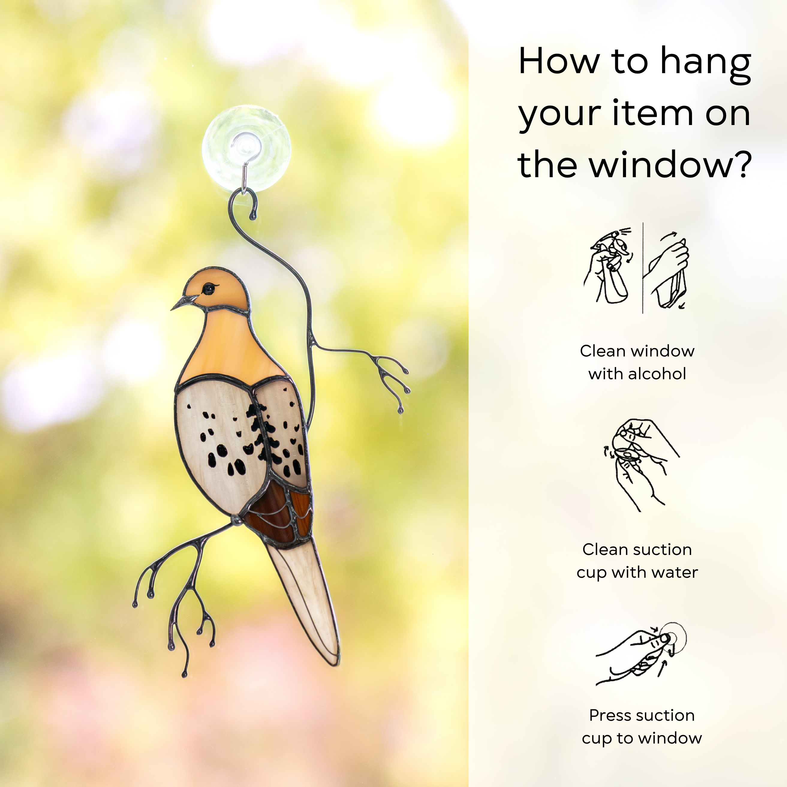 Glass mourning dove attached to window with a suction cup and hanging instructions on side: clean window and suction cup, press a cup to the surface.