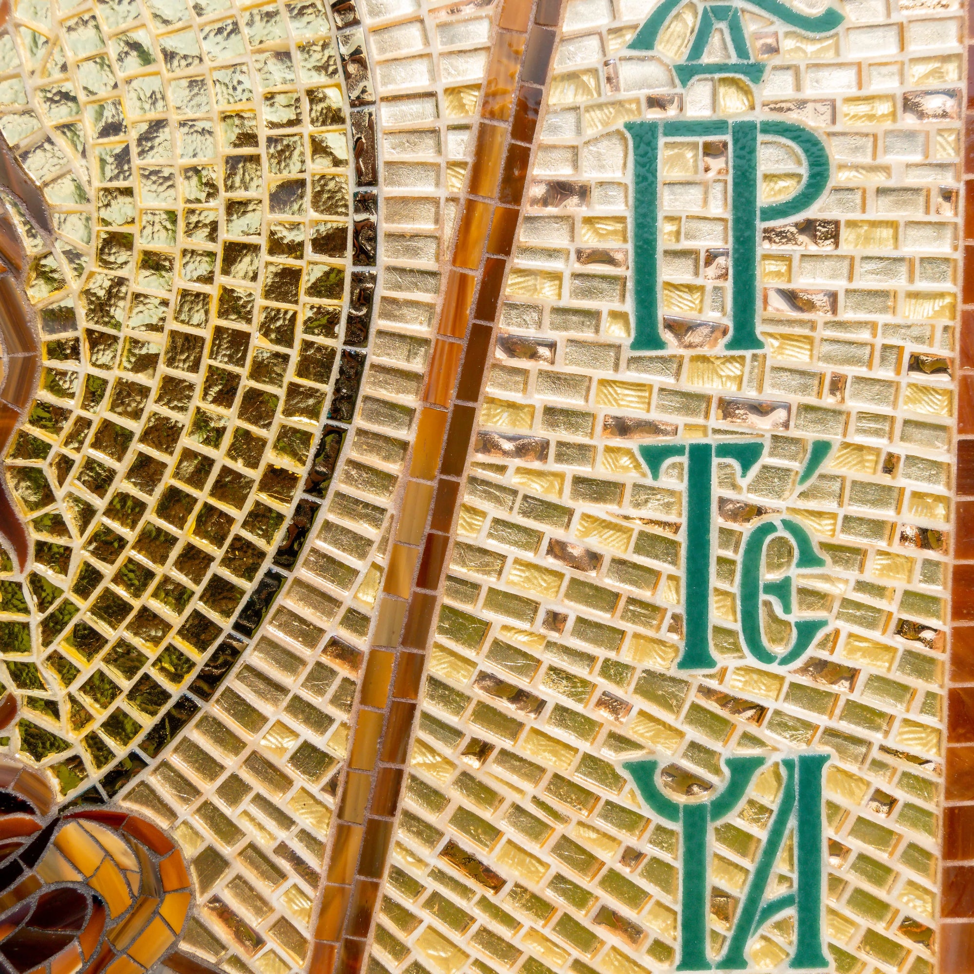 Close-up of mosaic letters on golden tiles spelling John the Baptist in Greek