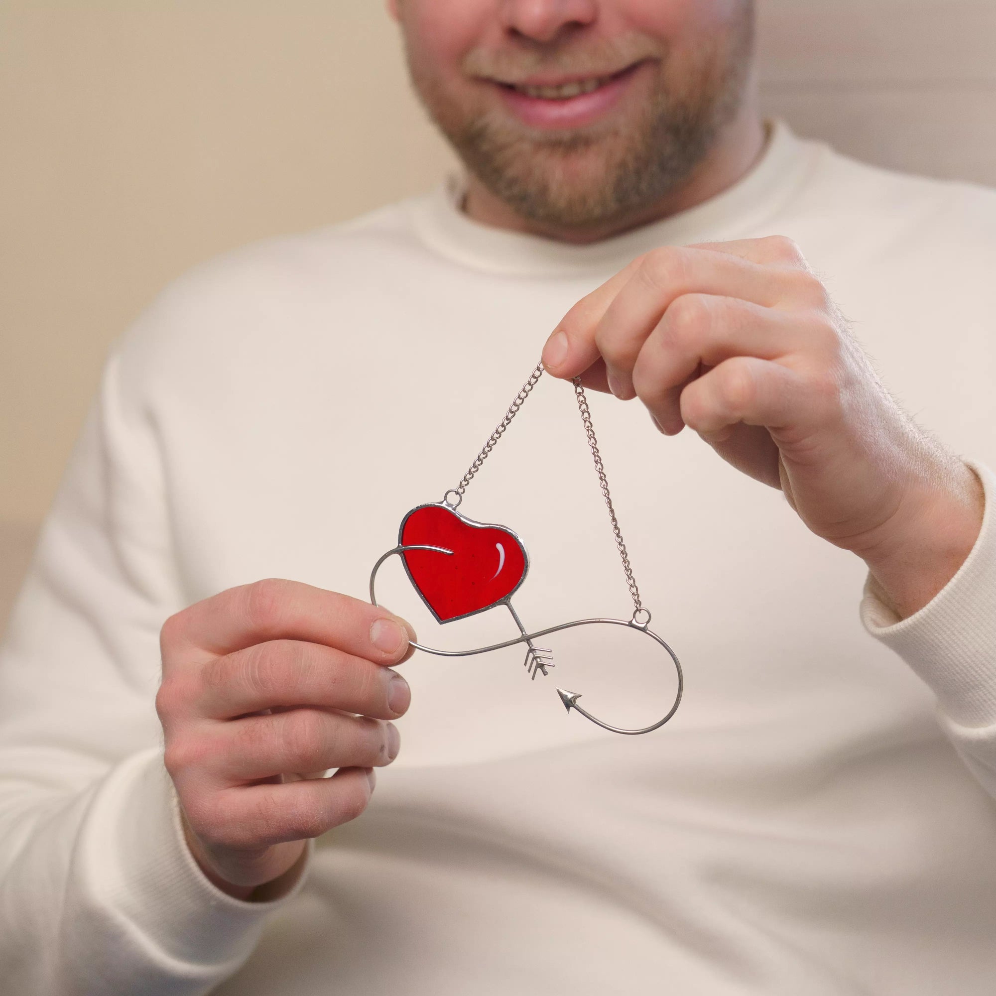 Infinity stained glass heart suncatcher held by two hands, symbolizing connection and eternal love.