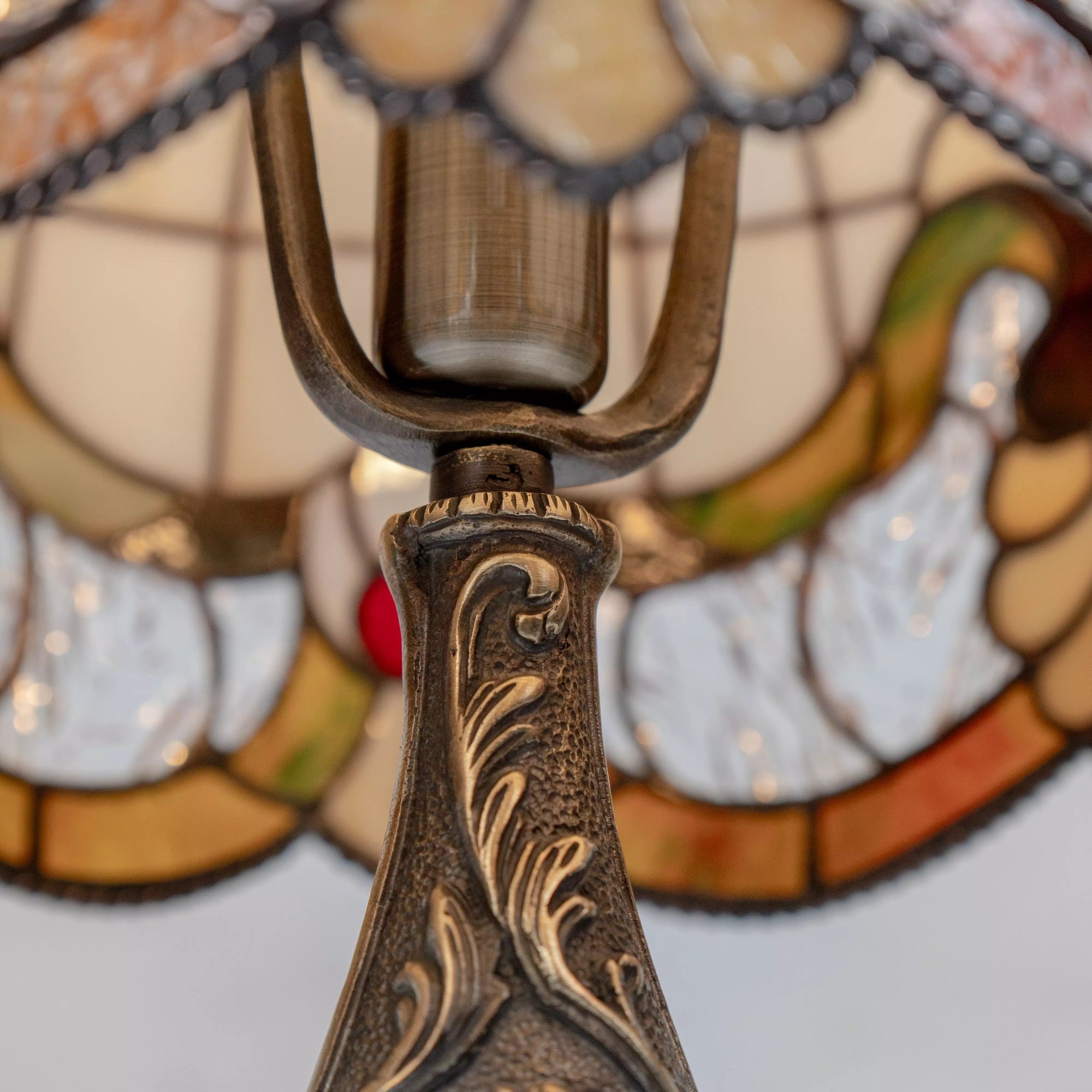 Interior of lamp showing bulb and metal holder with colorful floral stained glass around