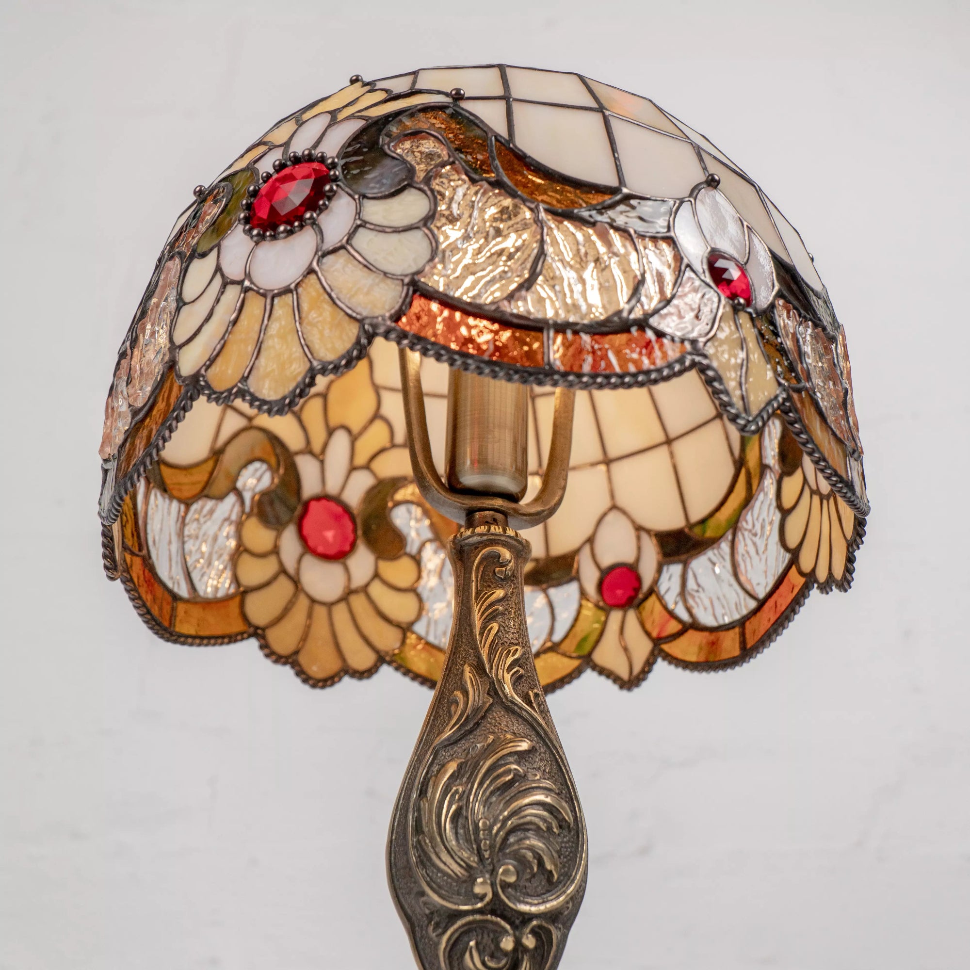 Inside view of stained glass lamp showing light bulb, wiring, and vibrant floral design